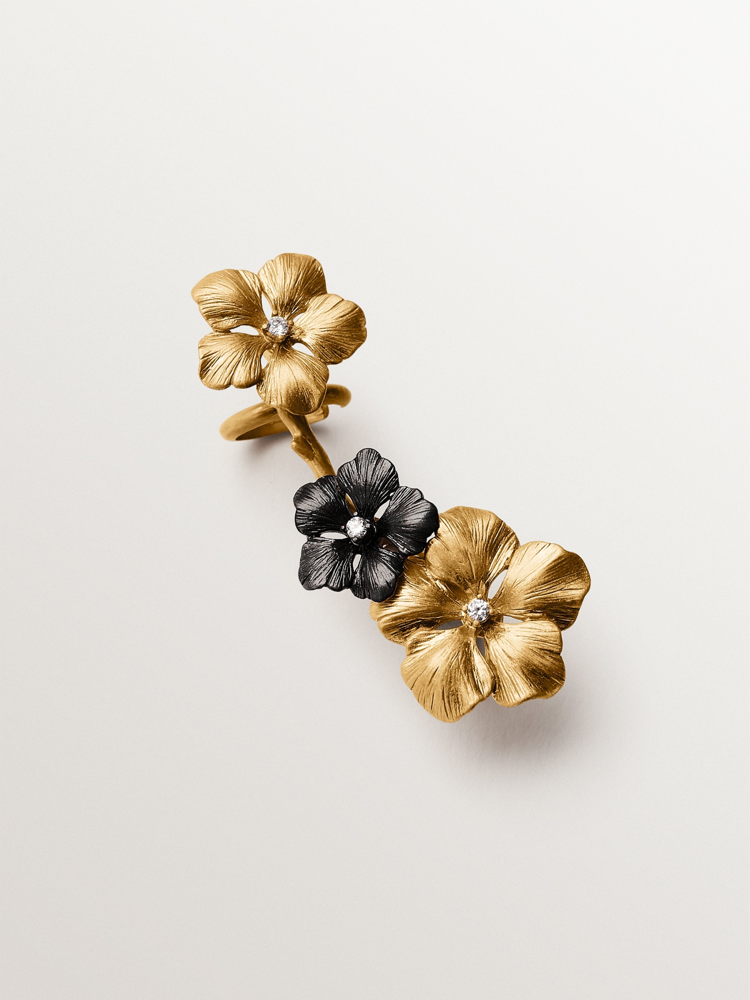 Climbing earcuff plated in yellow gold with crystals and flower motifs