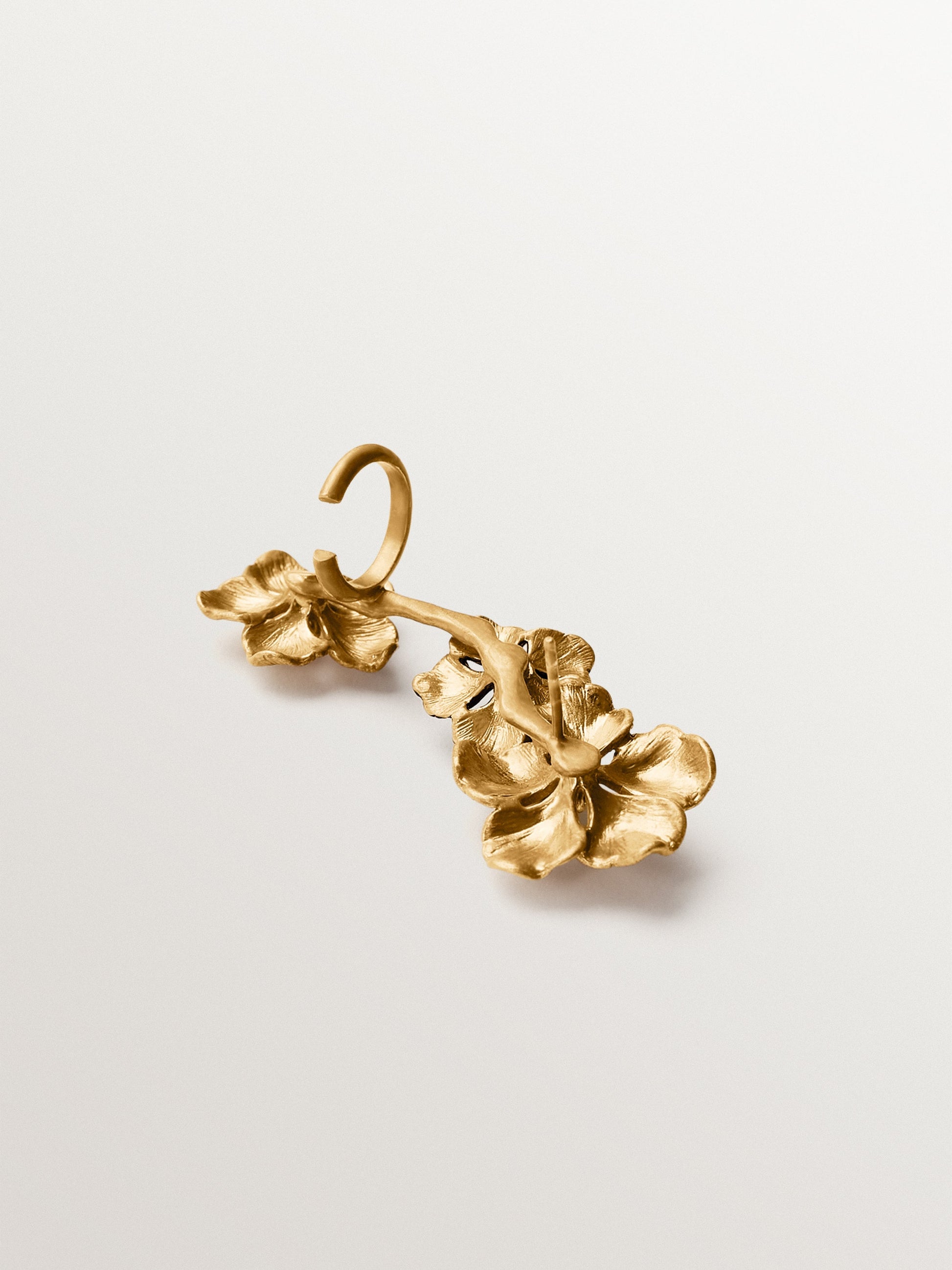 Climbing earcuff plated in yellow gold with crystals and flower motifs