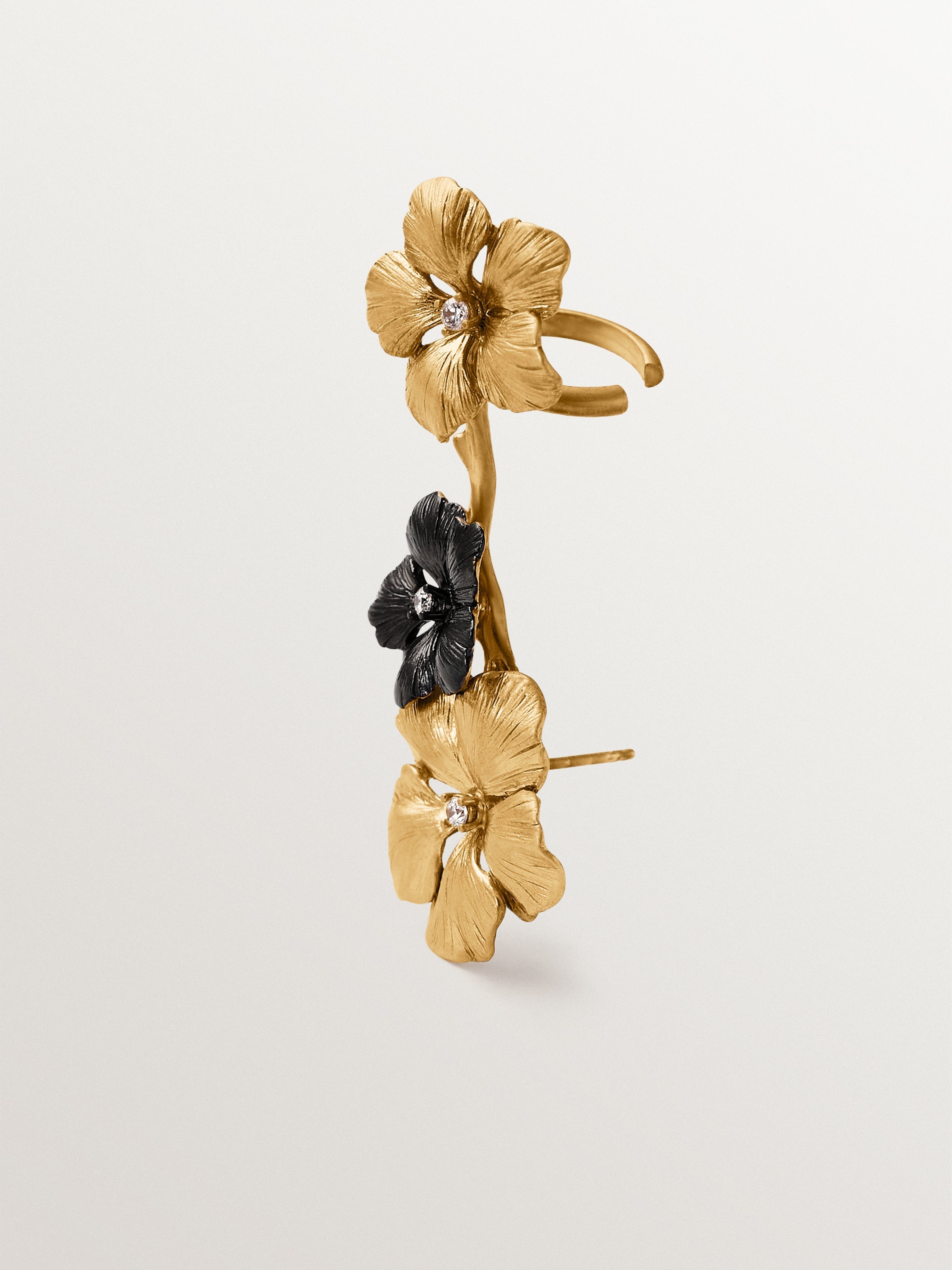 Climbing earcuff plated in yellow gold with crystals and flower motifs