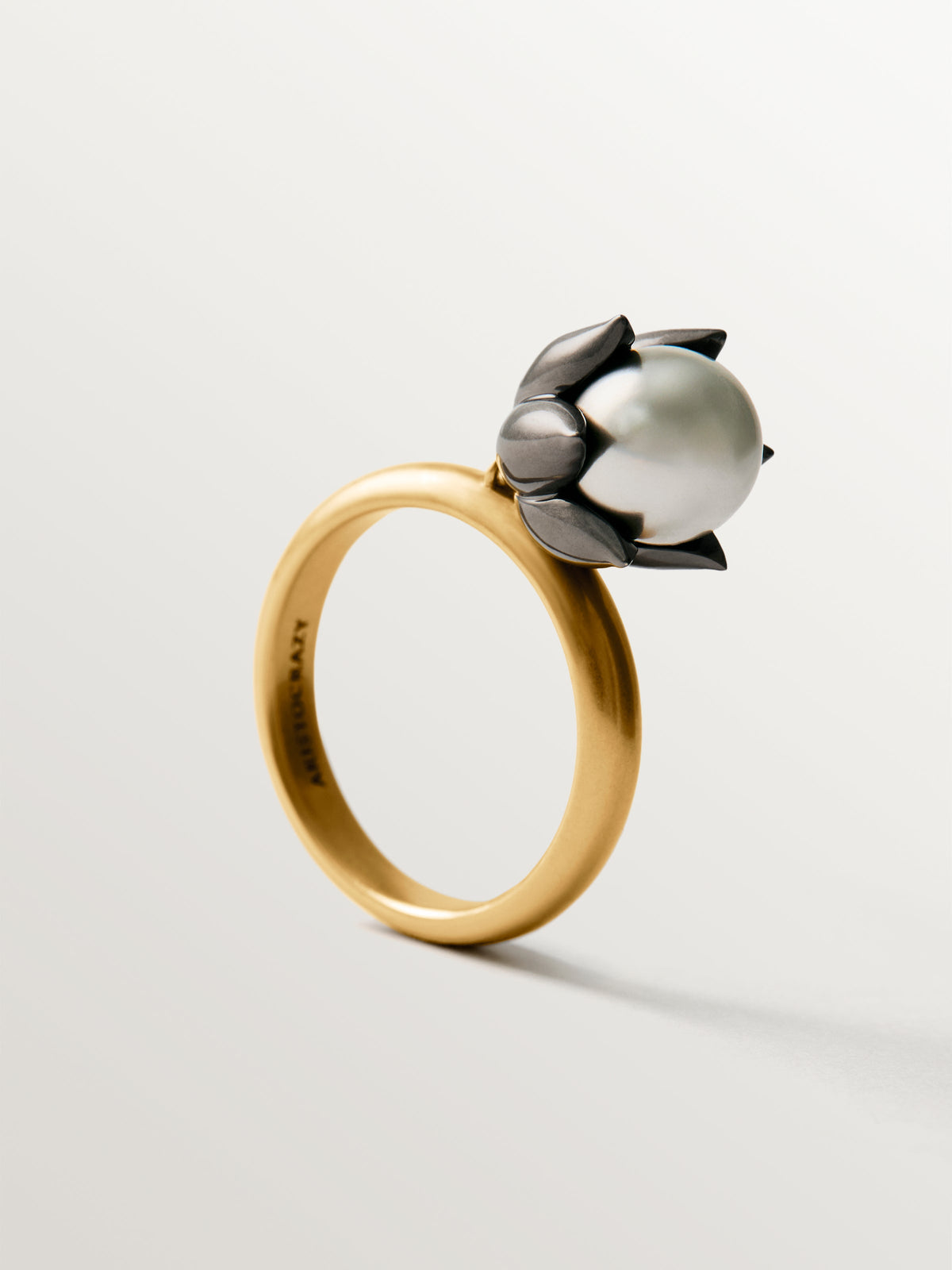 Two-tone yellow gold-plated ring with gunmetal finish and flower-shaped grey crystal