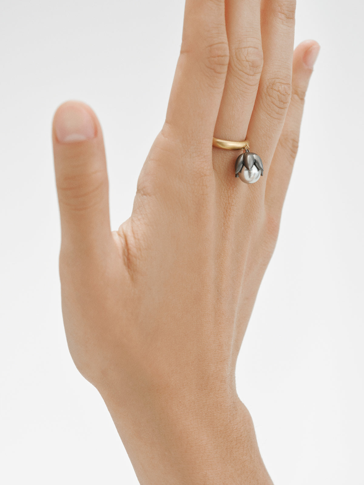 Two-tone ring plated in yellow gold with a gunmetal finish, gray pearl and flower shape