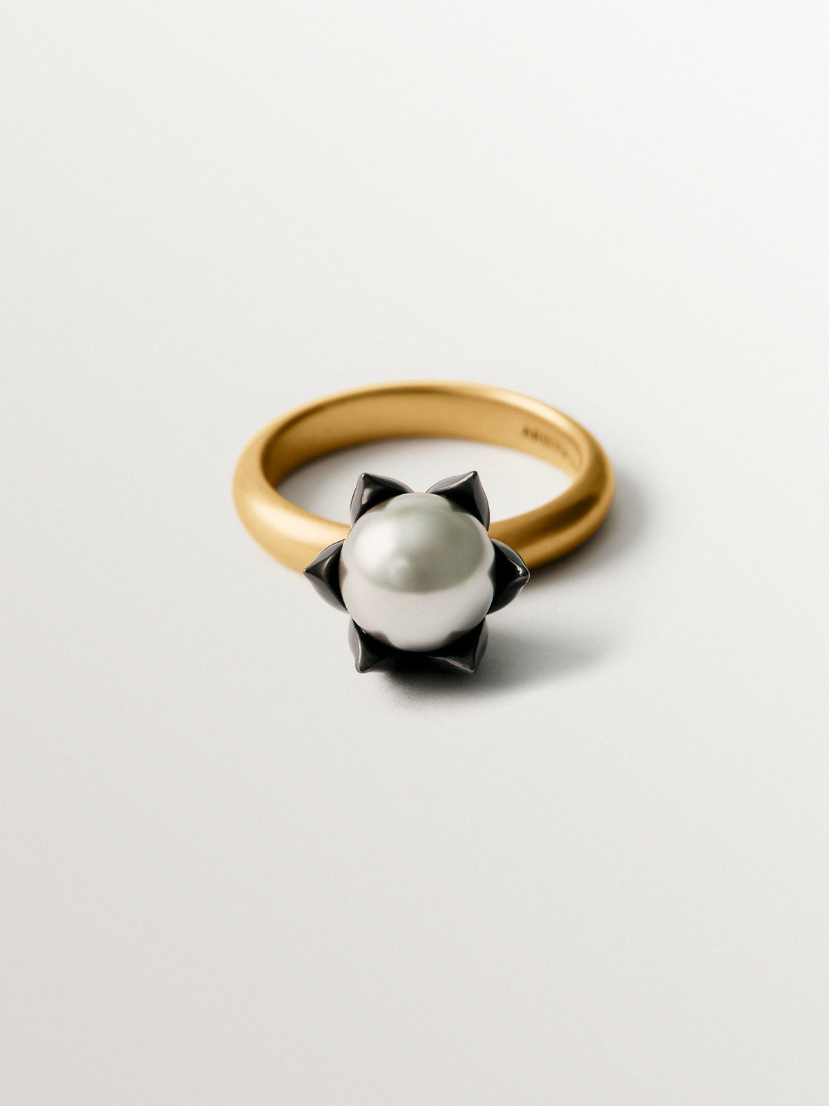Two-tone yellow gold-plated ring with gunmetal finish and flower-shaped grey crystal