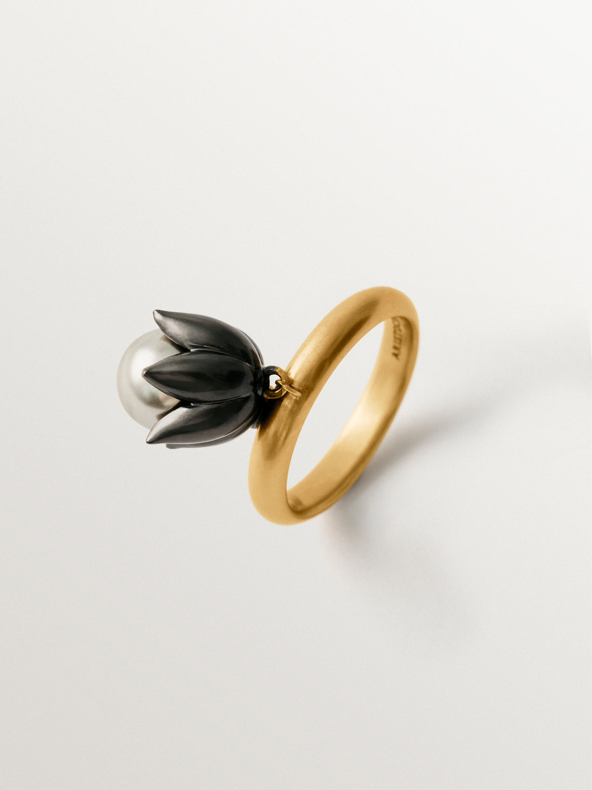 Two-tone yellow gold-plated ring with gunmetal finish and flower-shaped grey crystal
