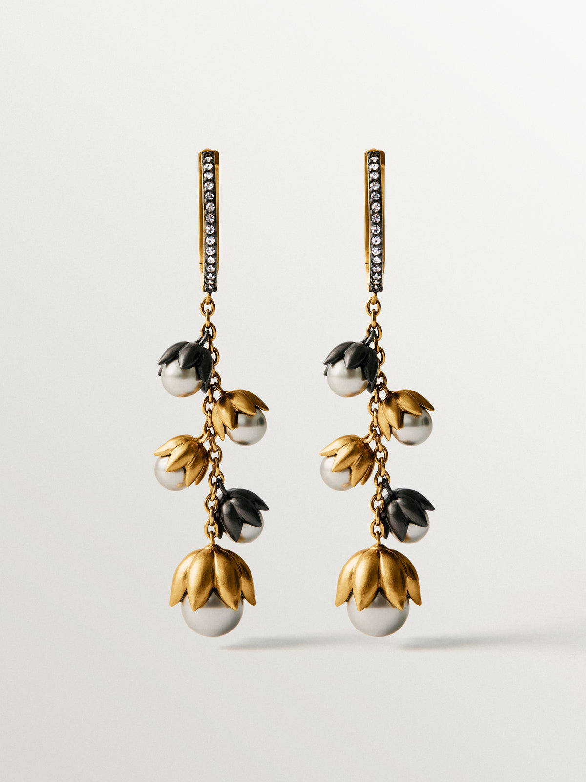 Two-tone yellow gold-plated earrings with gunmetal finish, white crystals and flower-shaped grey crystals