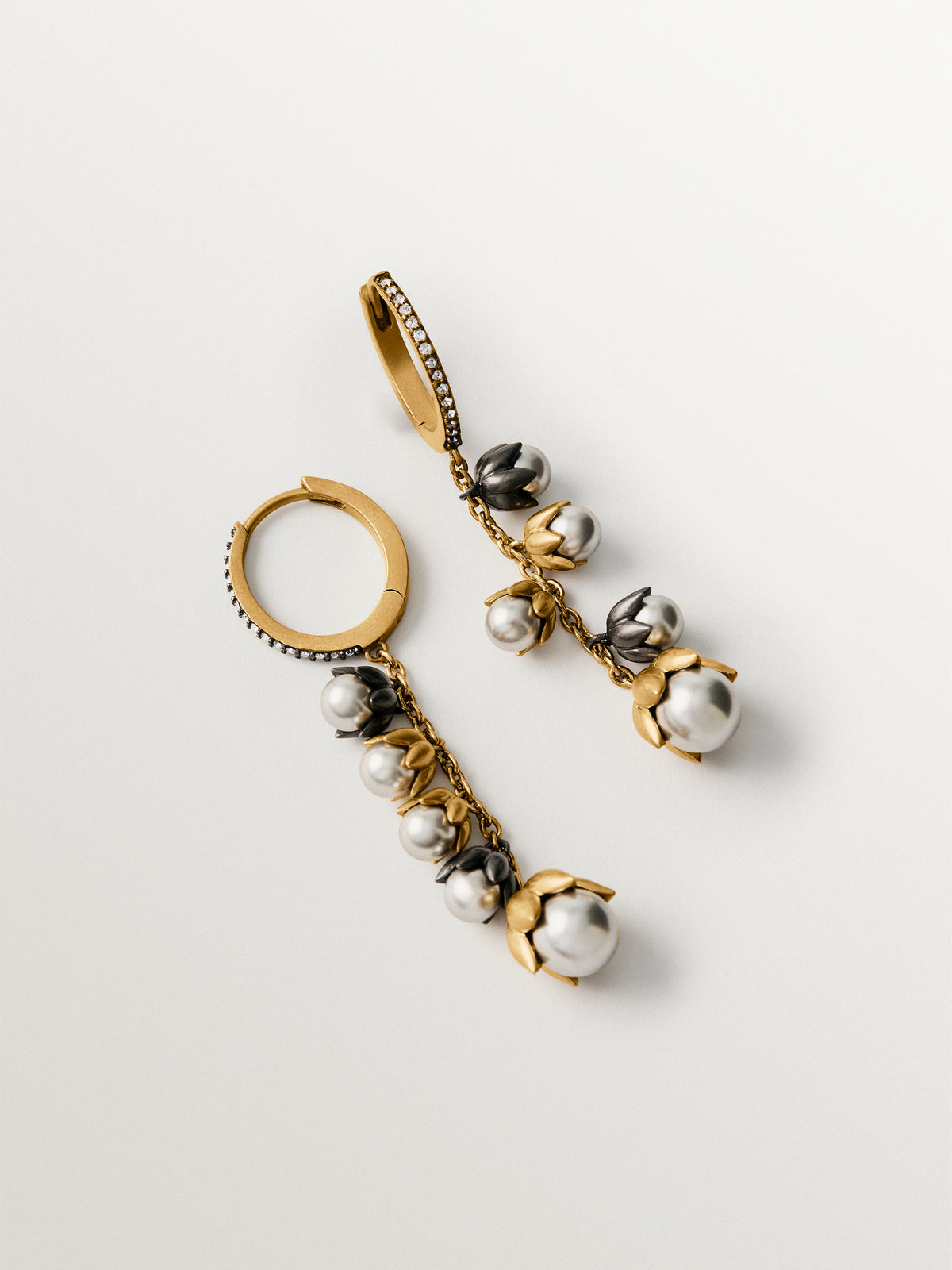 Two-tone yellow gold-plated earrings with gunmetal finish, white crystals and flower-shaped grey crystals