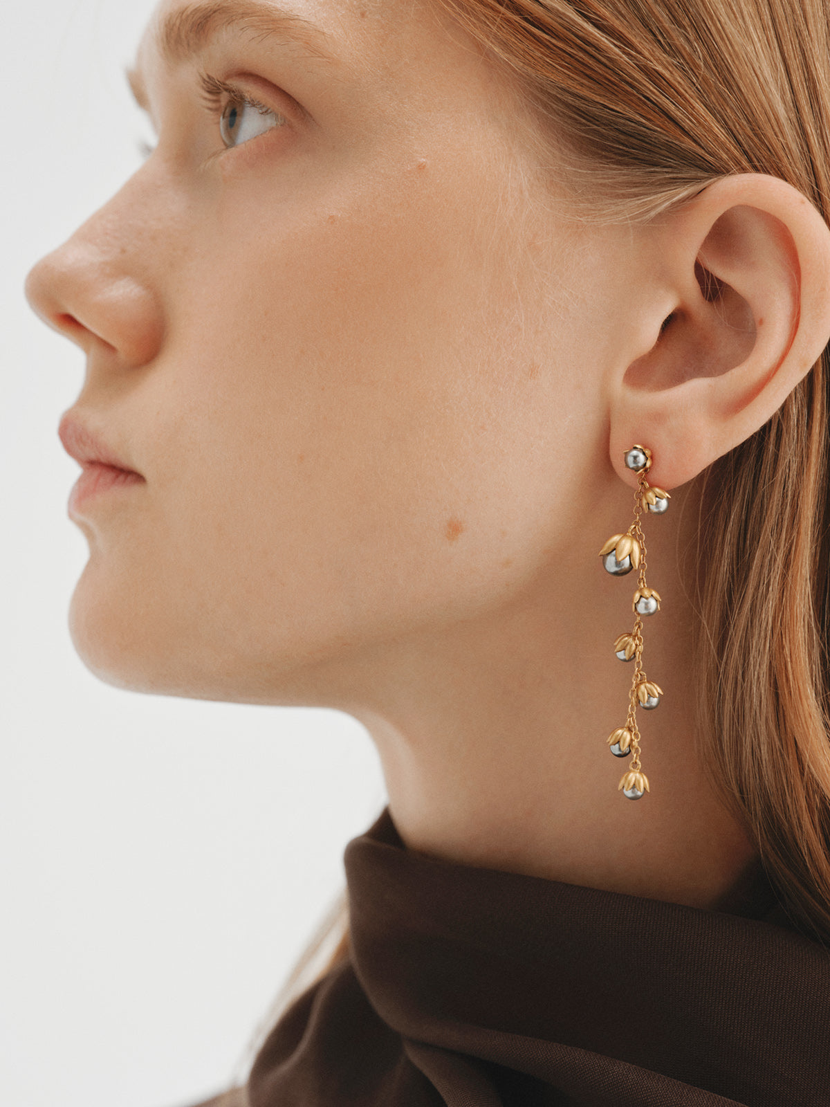 Two-tone single earring plated in yellow gold with a gunmetal finish, gray pearls and floral motifs