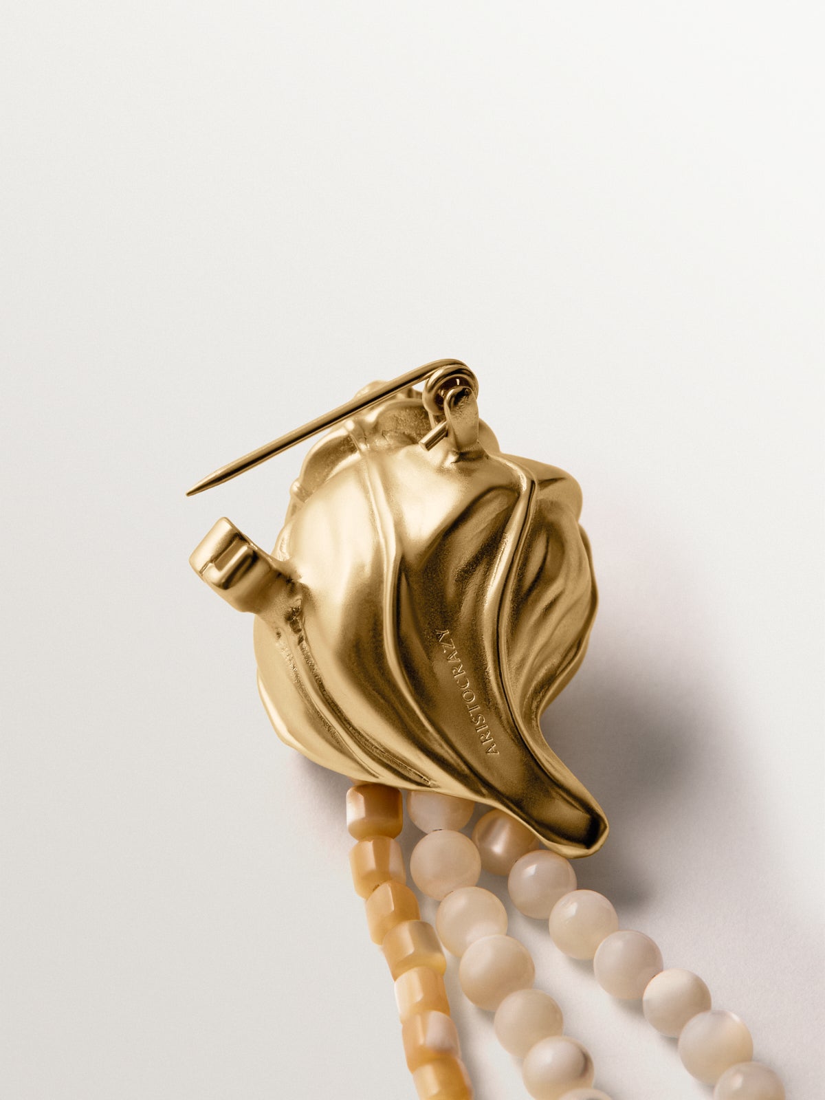 Yellow gold plated brooch with crystals, white balls and shell shape