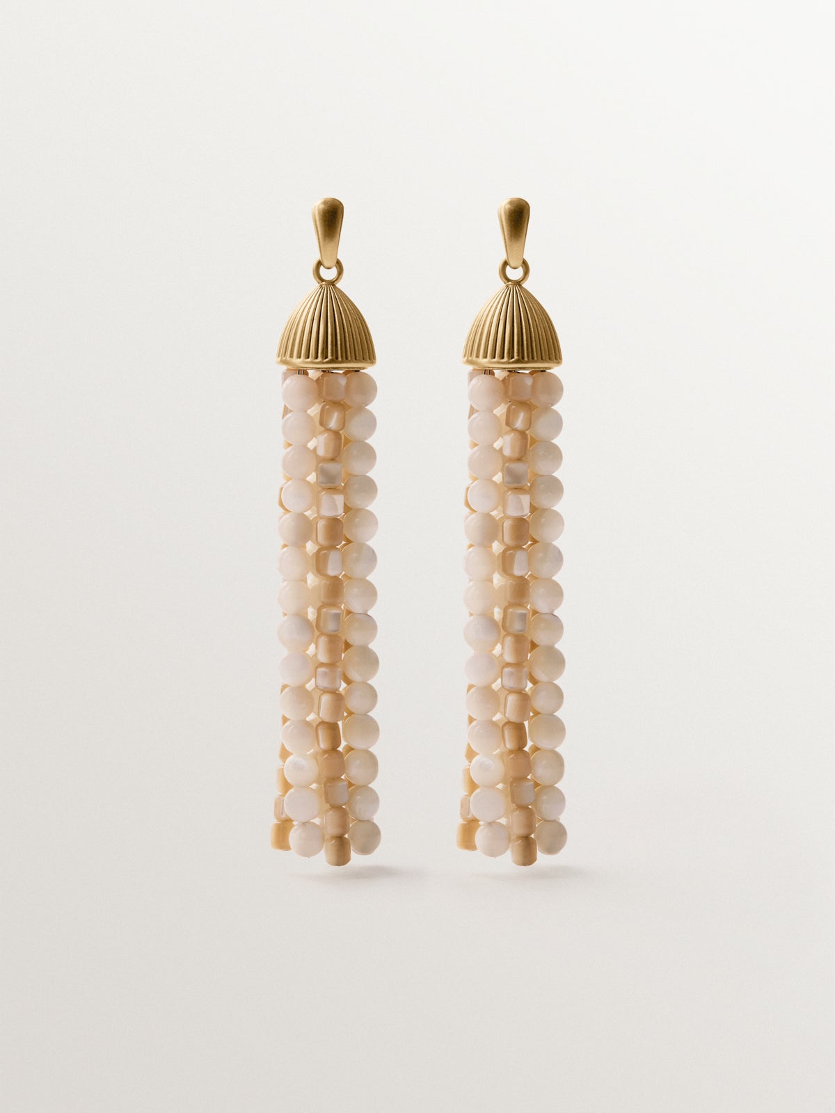 Cascading earrings plated in yellow gold with white beads