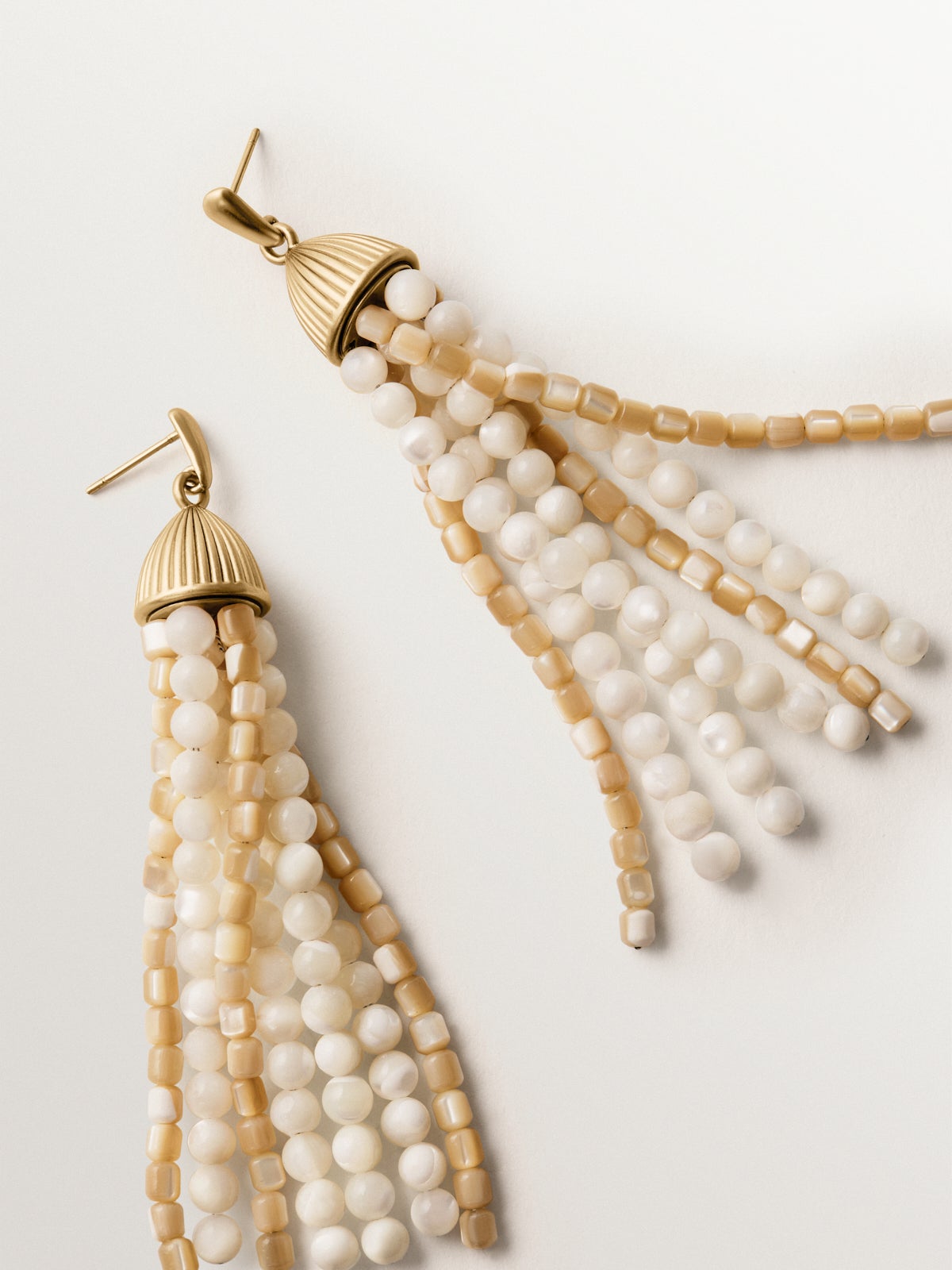 Cascading earrings plated in yellow gold with white beads