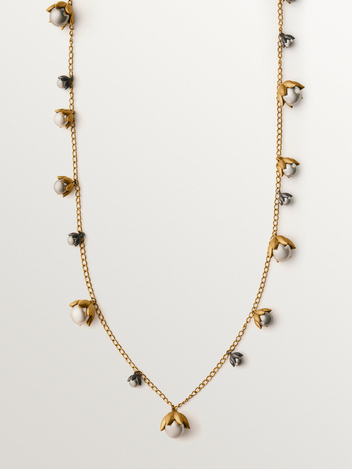 Two-tone yellow gold-plated pendant with gunmetal finish and flower-shaped grey crystals