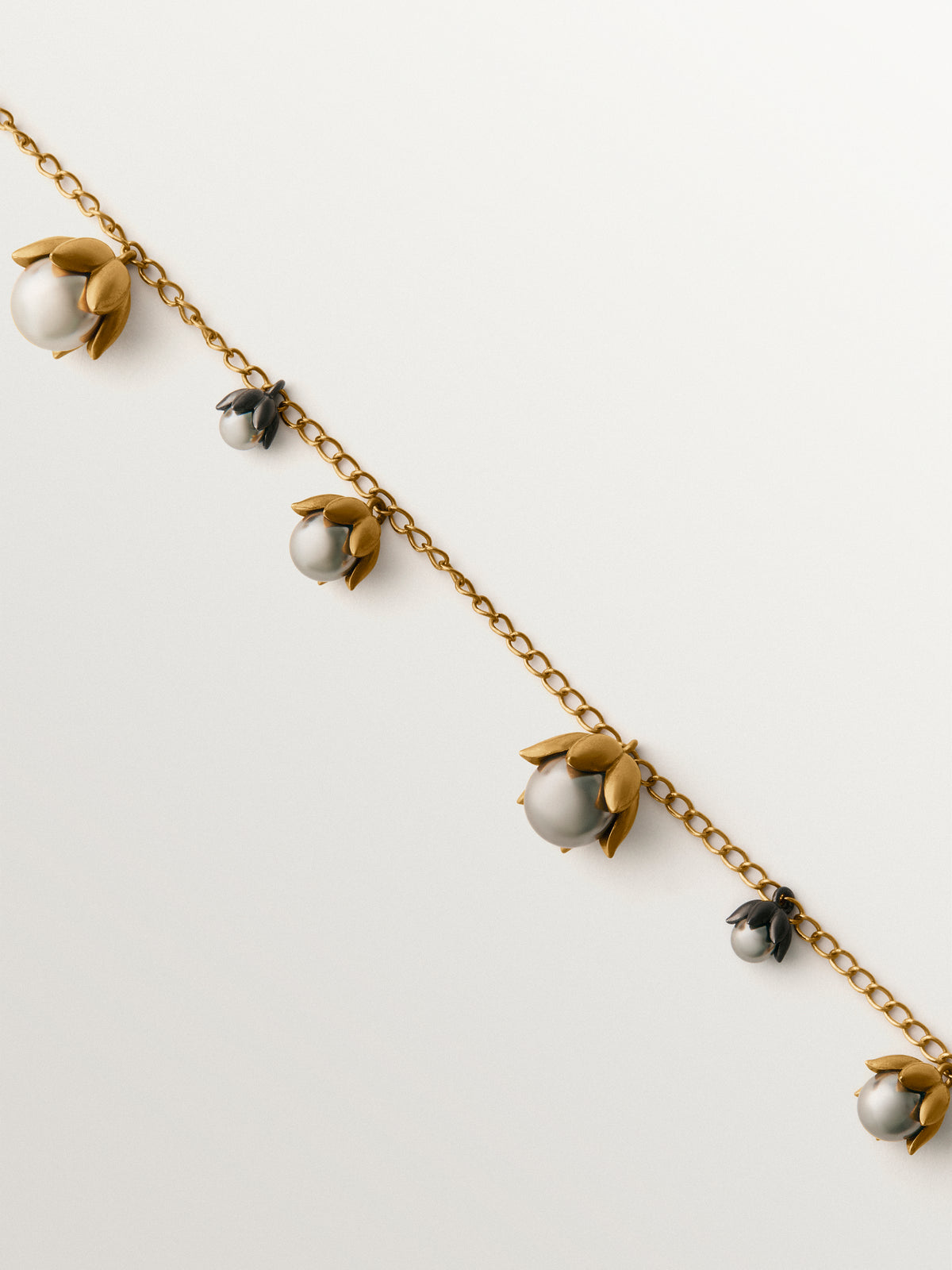 Two-tone yellow gold-plated pendant with gunmetal finish and flower-shaped grey crystals