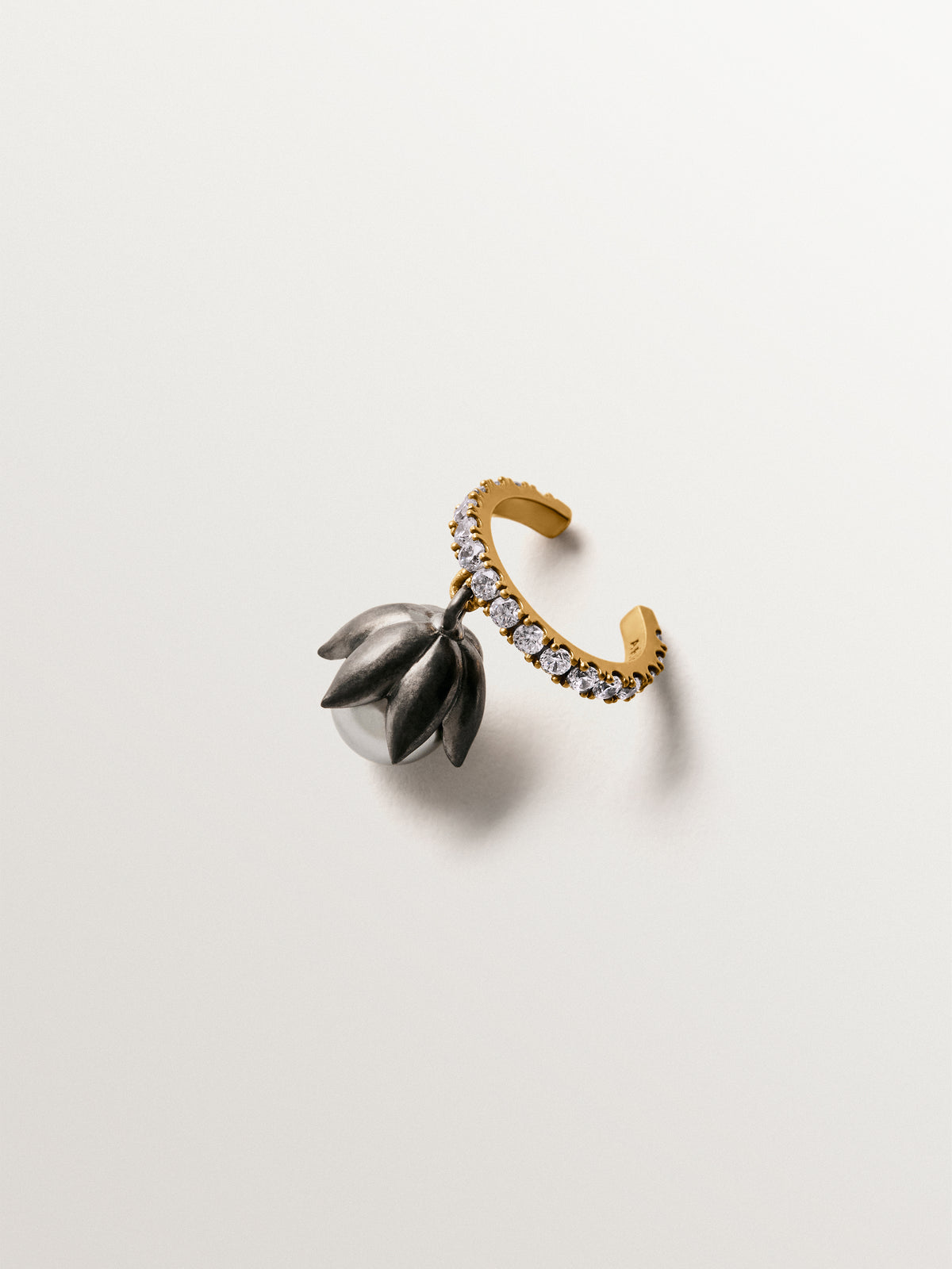 Two-tone yellow gold-plated ear cuff with gunmetal finish, white crystals and flower-shaped grey crystal