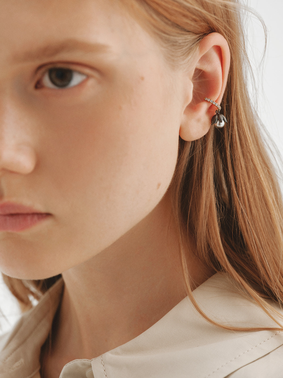 Two-tone yellow gold-plated ear cuff with gunmetal finish, white crystals and flower-shaped grey crystal