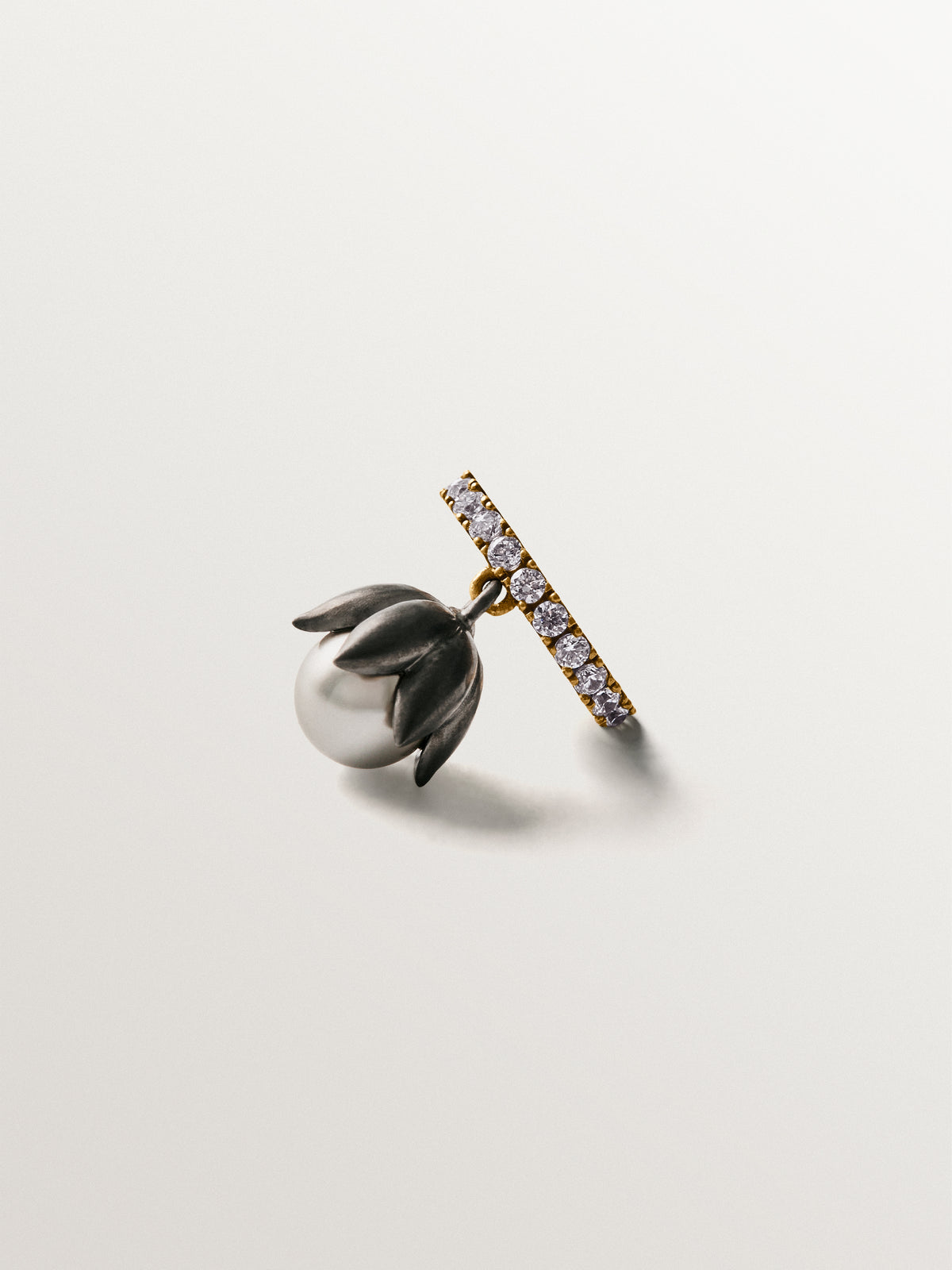 Two-tone yellow gold-plated ear cuff with gunmetal finish, white crystals and flower-shaped grey crystal