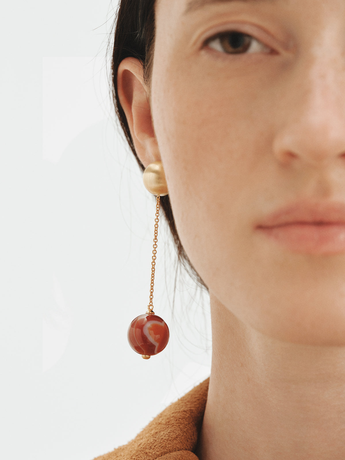Long earrings with brushed 18K yellow gold plating, red agate and sphere motif