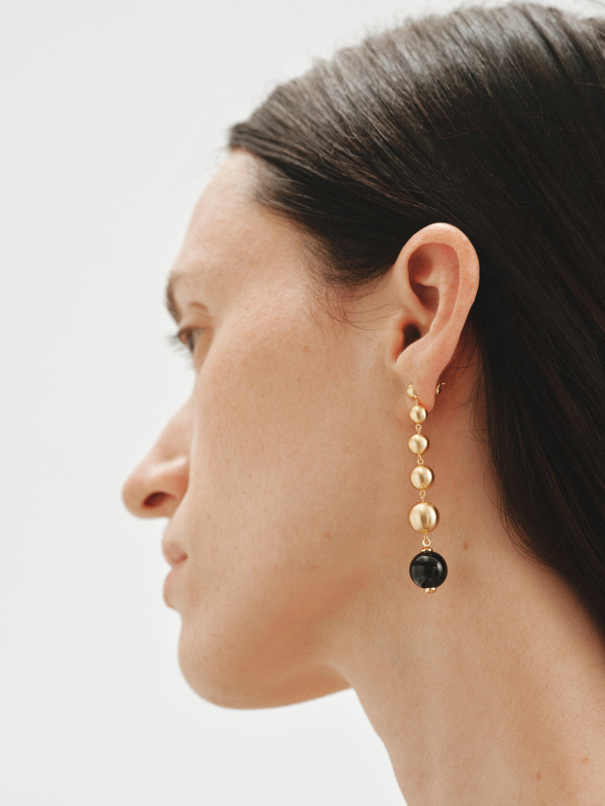 Long earrings with brushed 18K yellow gold plating, black agate and sphere motifs
