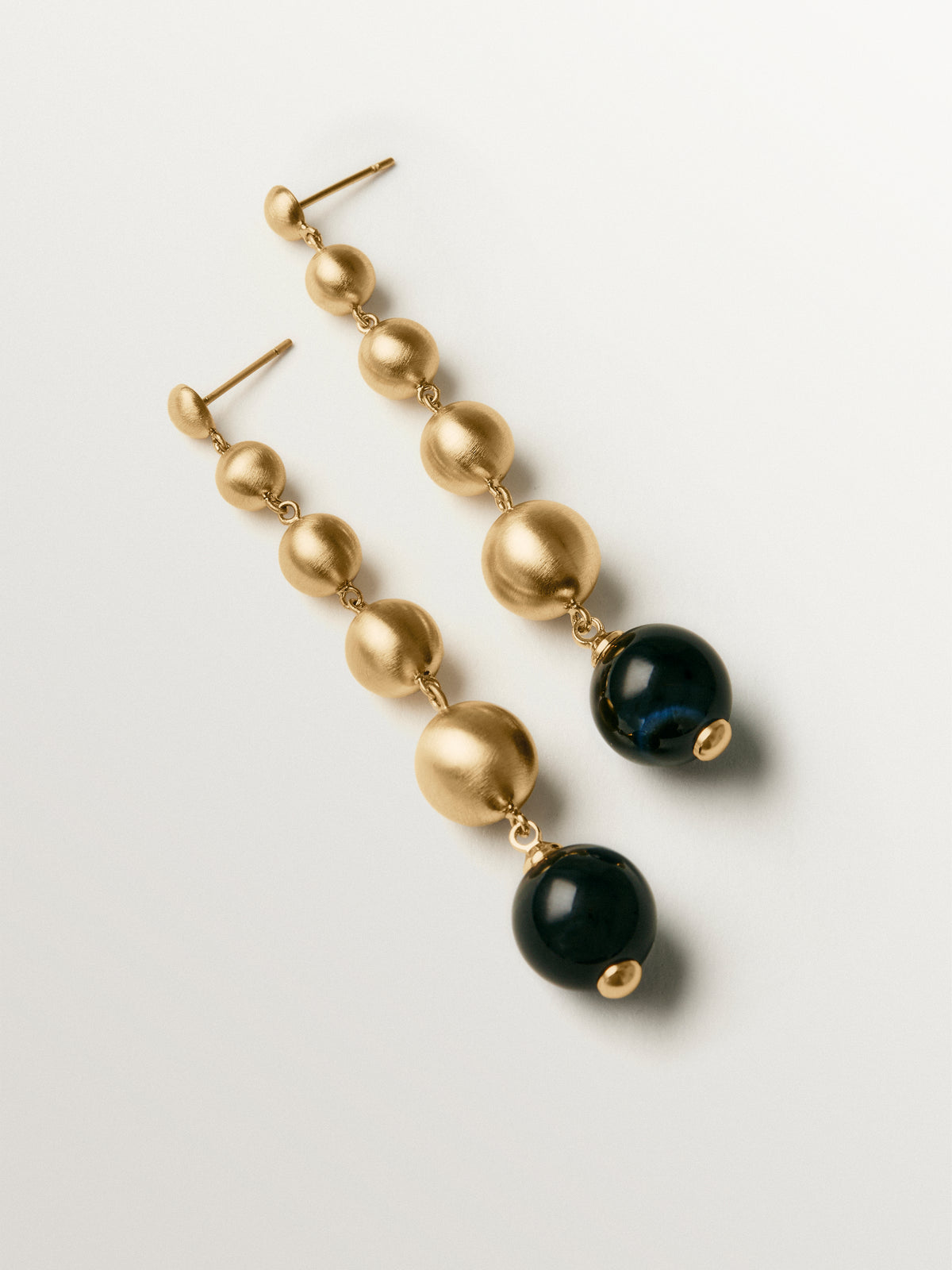 Long earrings with brushed 18K yellow gold plating, black agate and sphere motifs