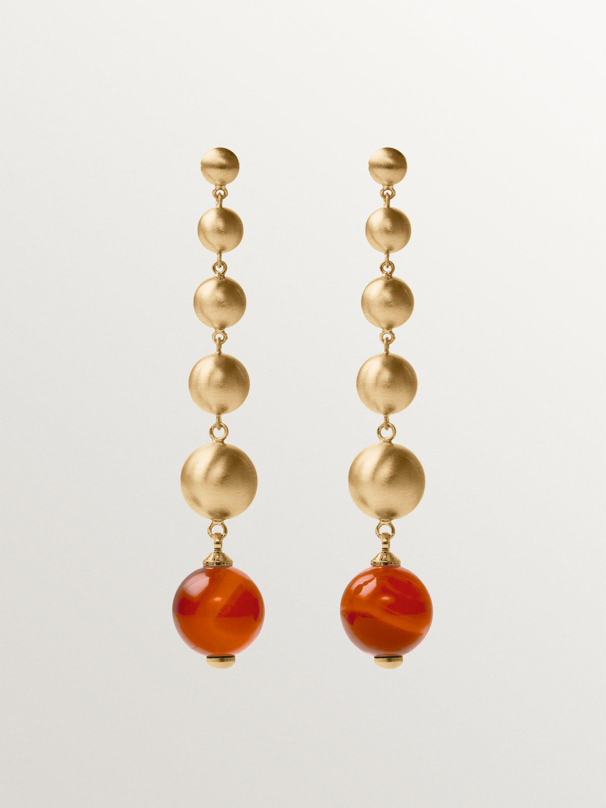 Brushed yellow gold-plated long earrings with red agate and sphere motifs
