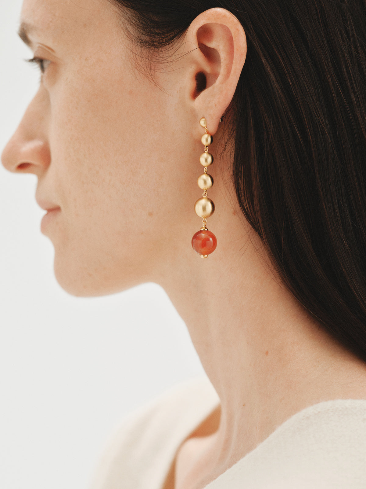 Long earrings with brushed 18K yellow gold plating, red agate and sphere motifs