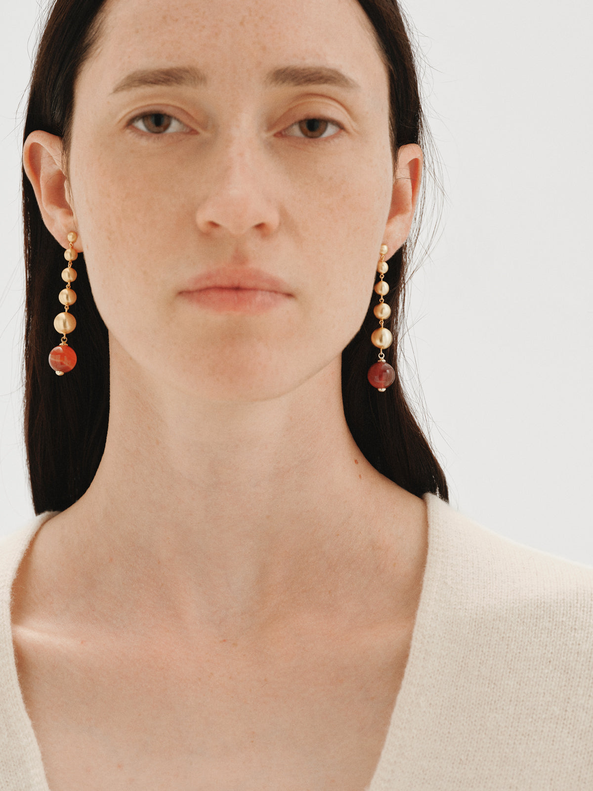 Long earrings with brushed 18K yellow gold plating, red agate and sphere motifs