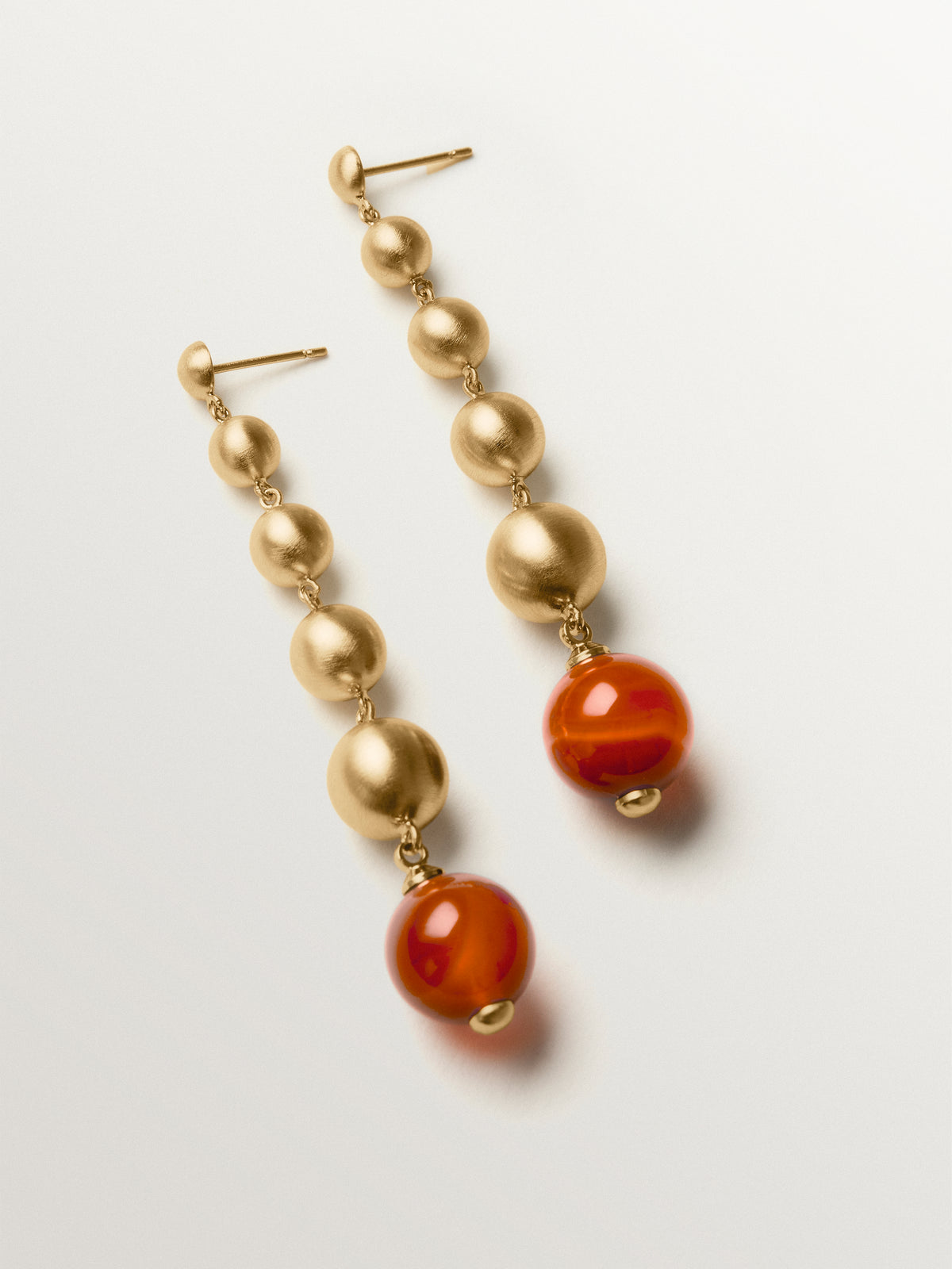 Long earrings with brushed 18K yellow gold plating, red agate and sphere motifs