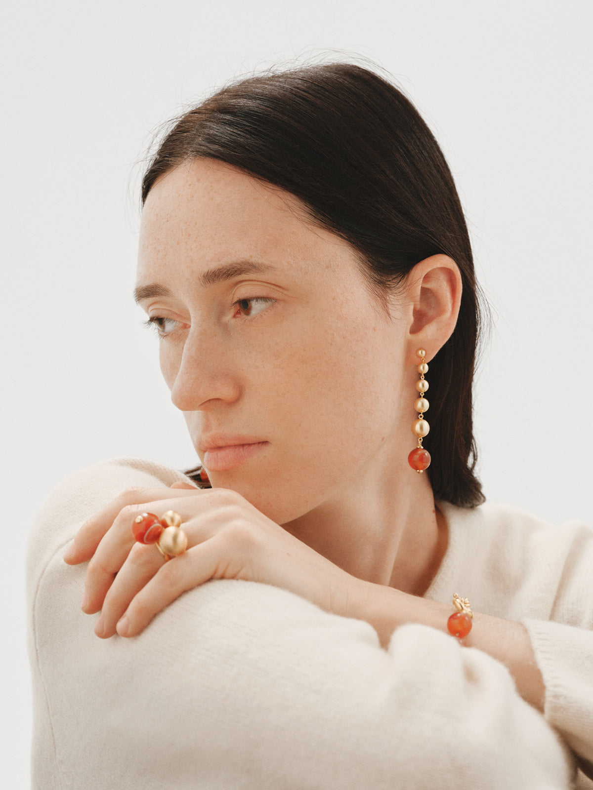 Long earrings with brushed 18K yellow gold plating, red agate and sphere motifs