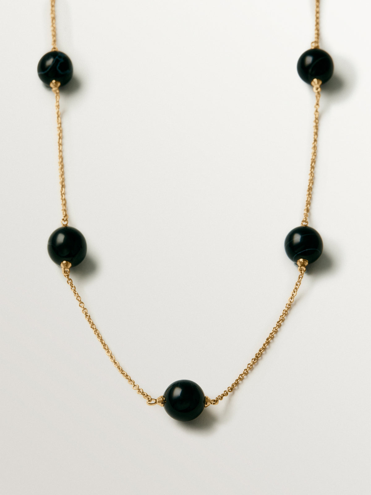 Yellow gold-plated necklace with black agate and sphere motif