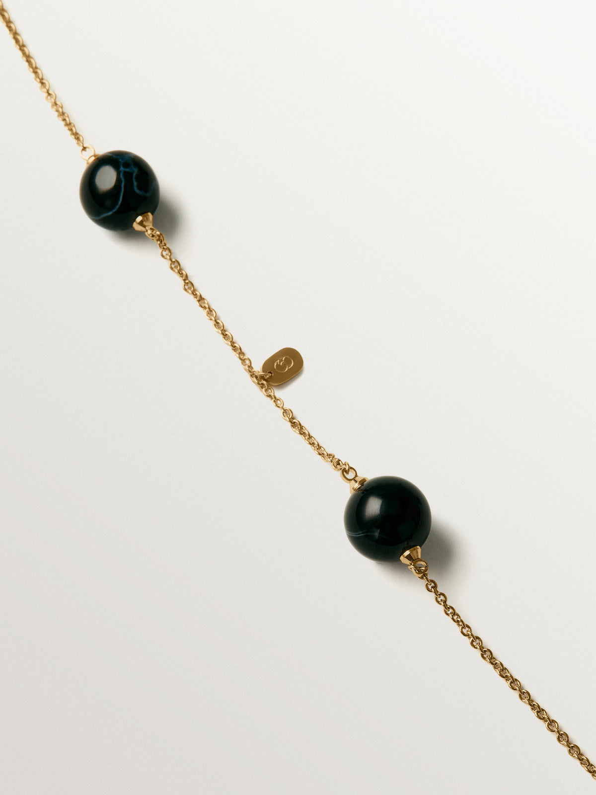 Yellow gold-plated necklace with black agate and sphere motif