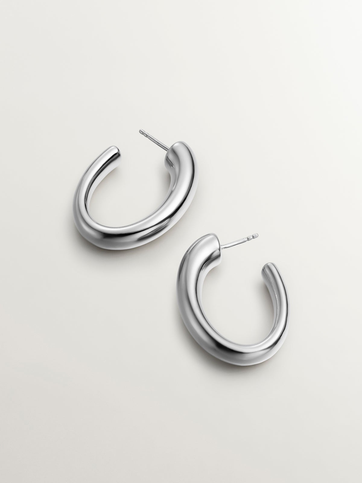 Large and thick 925 silver hoop earrings with an oval shape