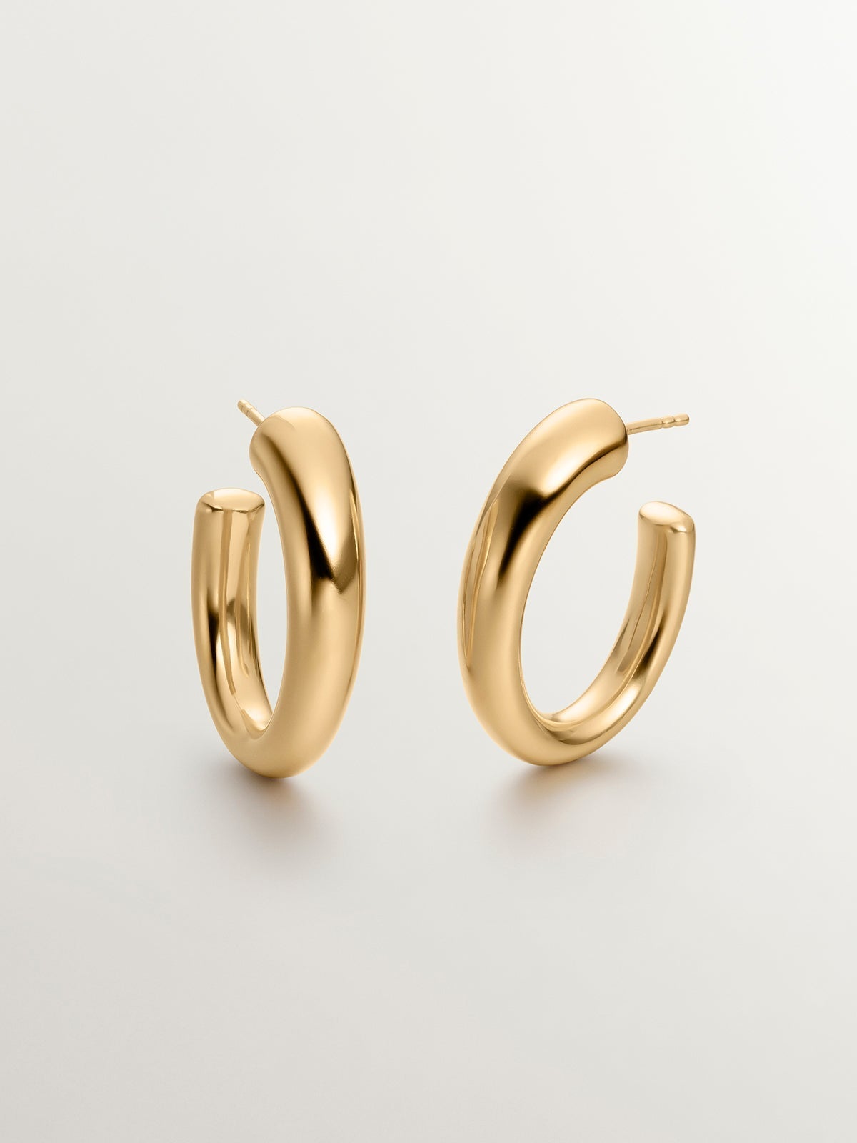 Large and thick hoop earrings made of 925 silver, bathed in 18K yellow gold, with an oval shape.