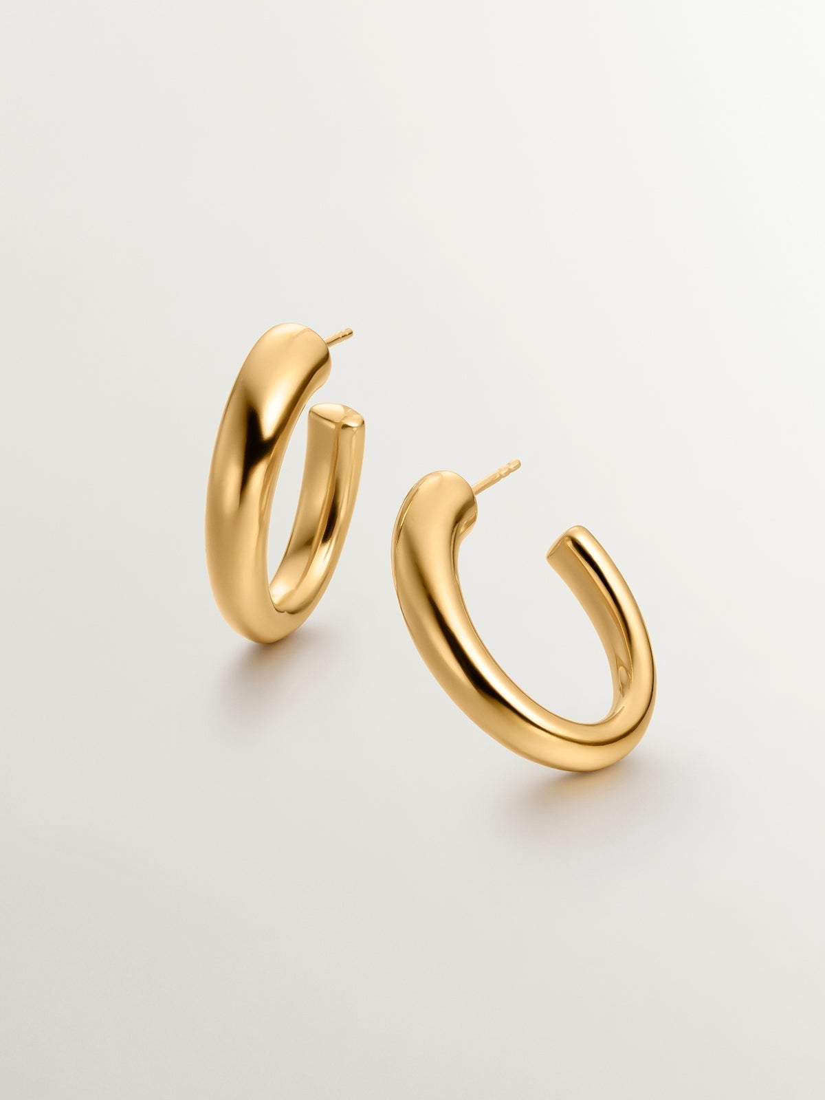 Large and thick hoop earrings made of 925 silver, bathed in 18K yellow gold, with an oval shape.