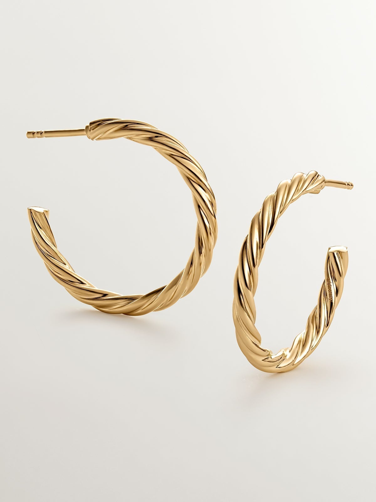 Large hoop earrings made of 925 silver coated in 18K yellow gold with fluted texture.