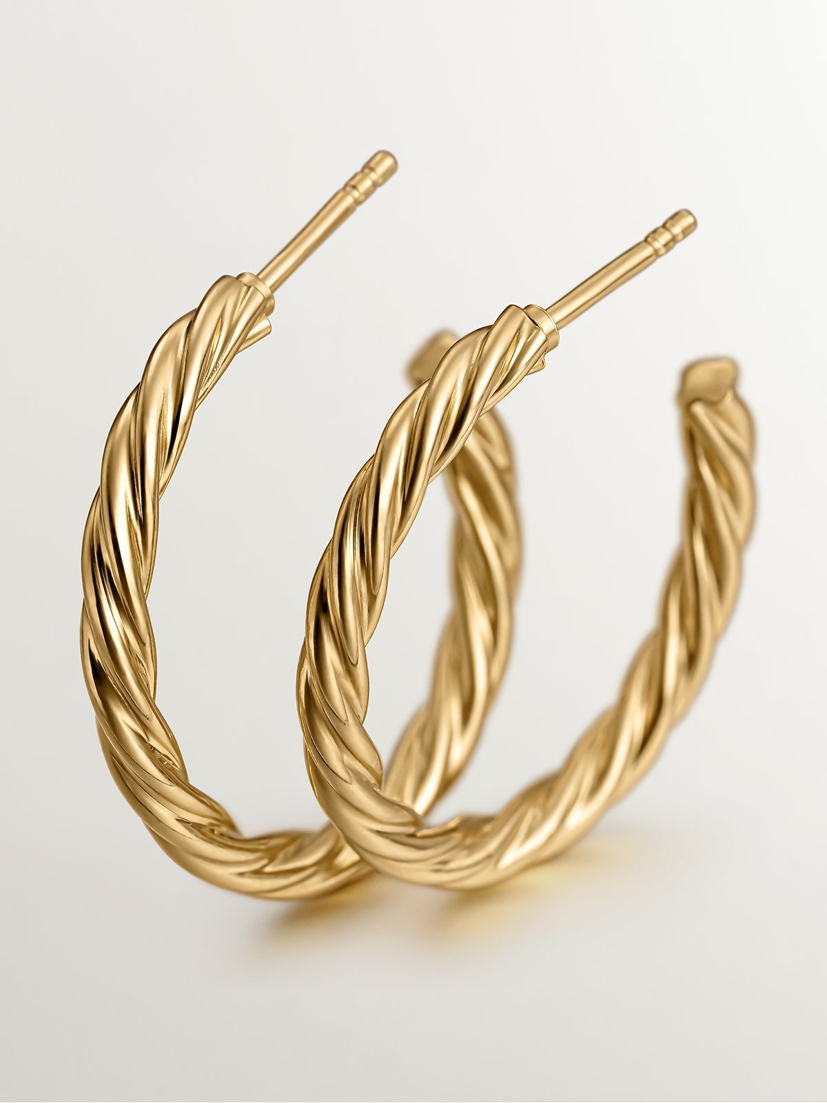 Large hoop earrings made of 925 silver coated in 18K yellow gold with fluted texture.