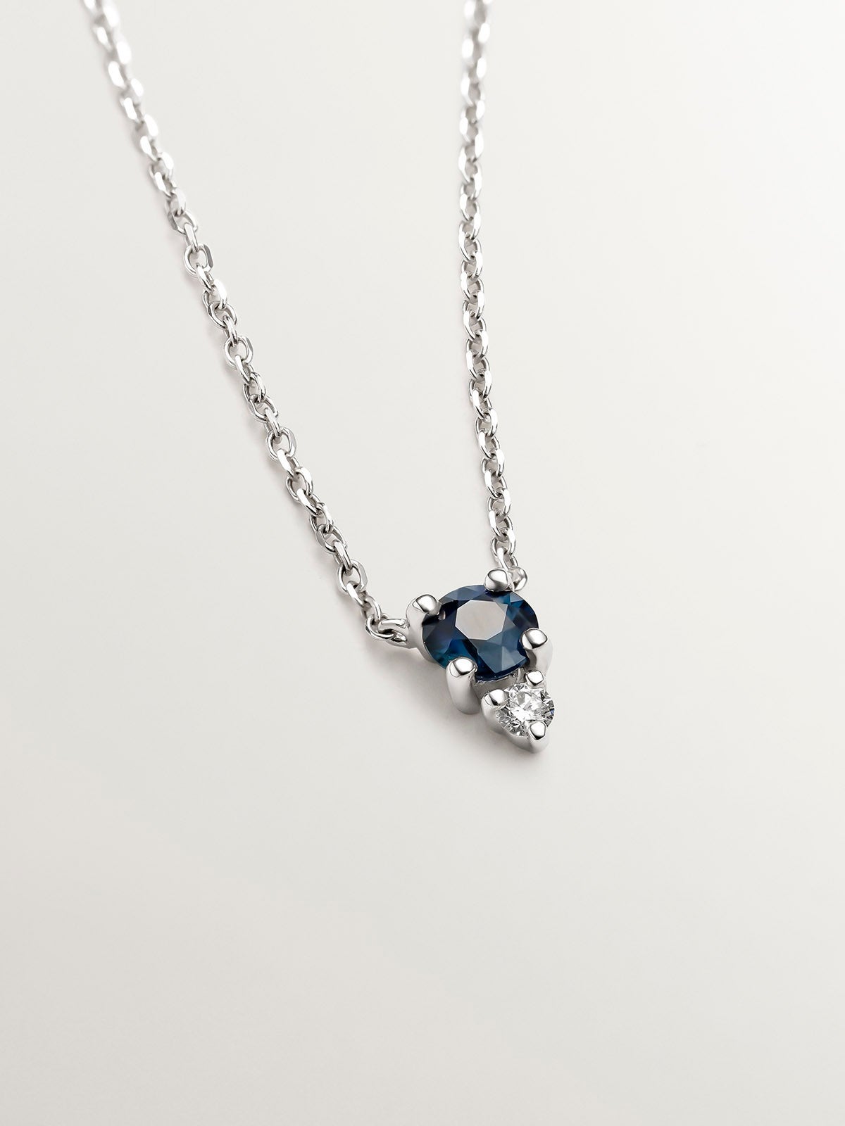 18K white gold pendant with sapphire and diamond.