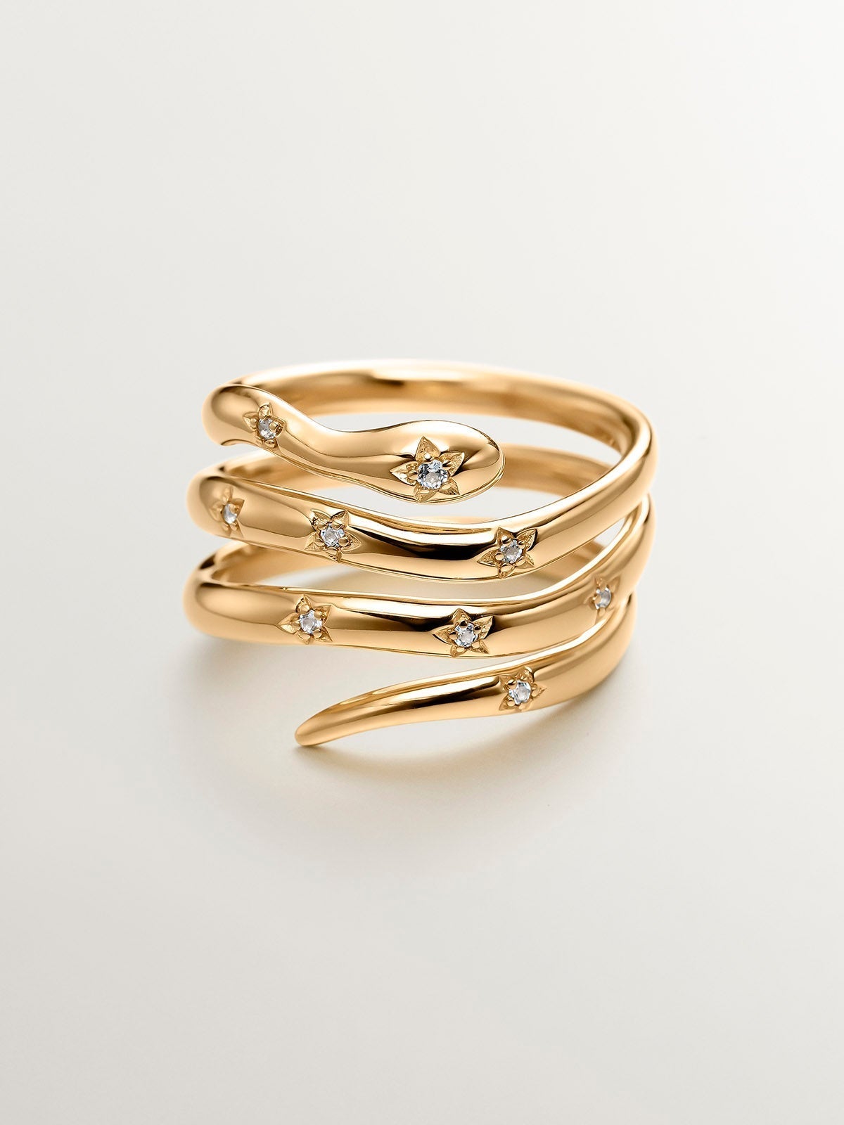 925 Silver triple ring bathed in 18K yellow gold with a snake shape and white topazes.