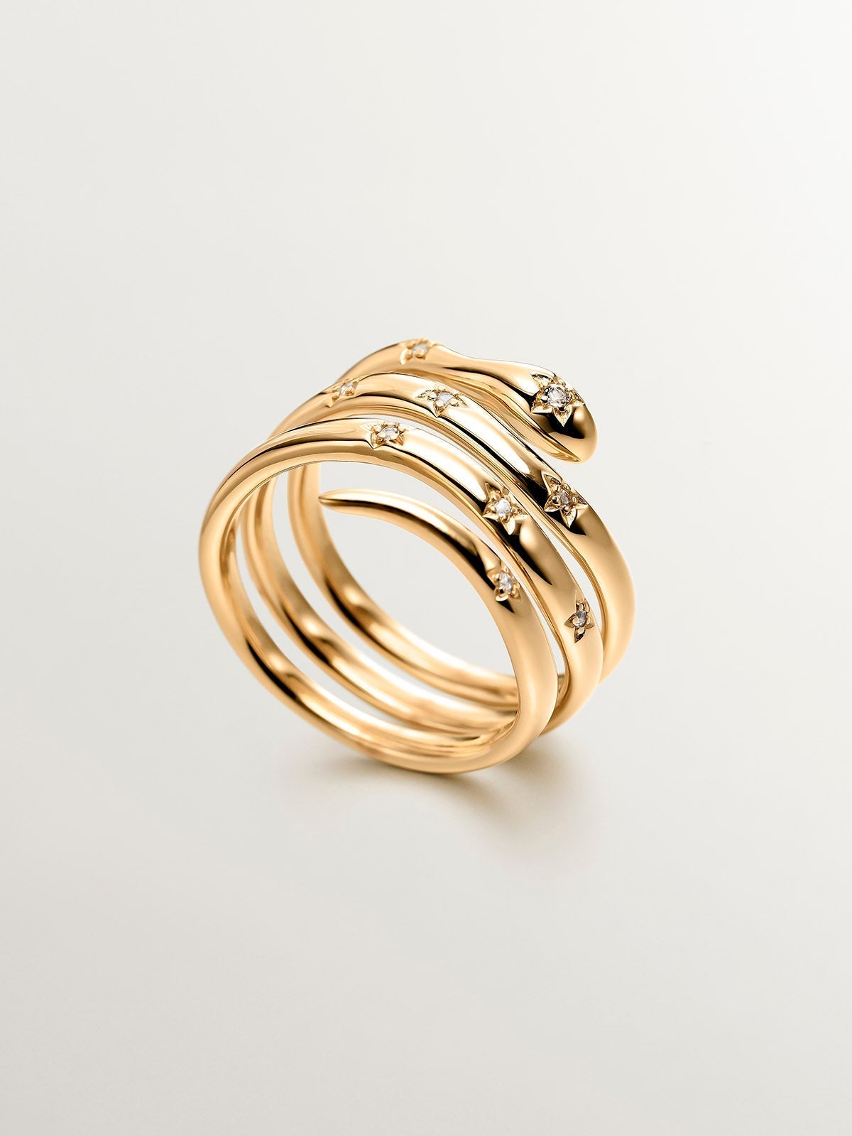 925 Silver triple ring bathed in 18K yellow gold with a snake shape and white topazes.