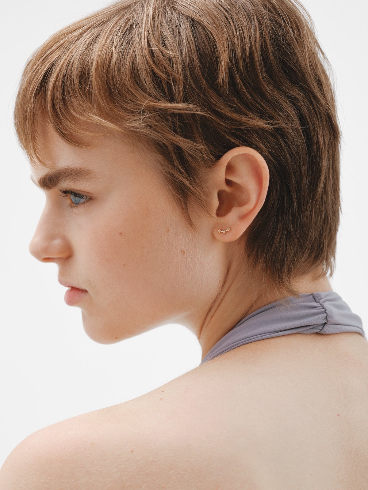 Single climbing earring made of 925 silver coated in 18K yellow gold with white topaz.