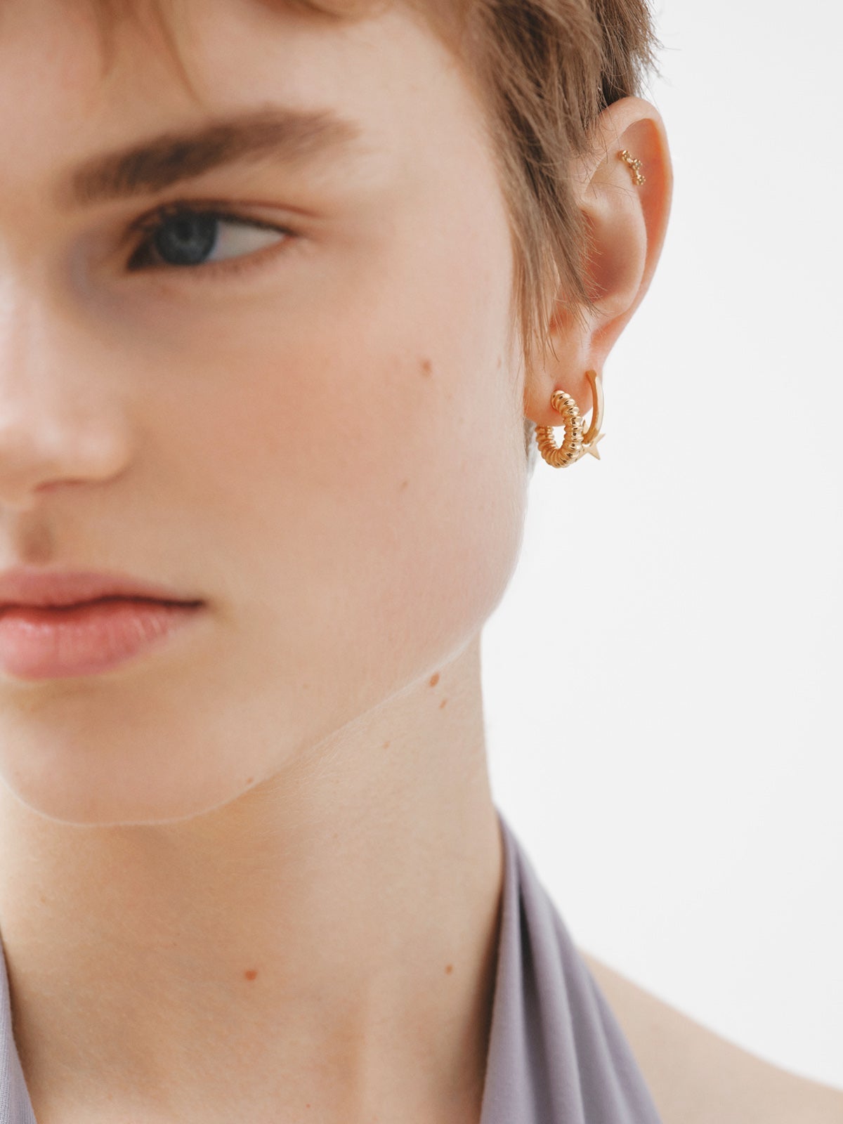 Single climbing earring made of 925 silver coated in 18K yellow gold with white topaz.