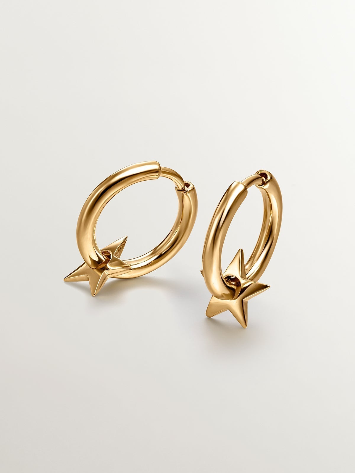 Small hoop earrings made of 925 silver, bathed in 18K gold with a star.