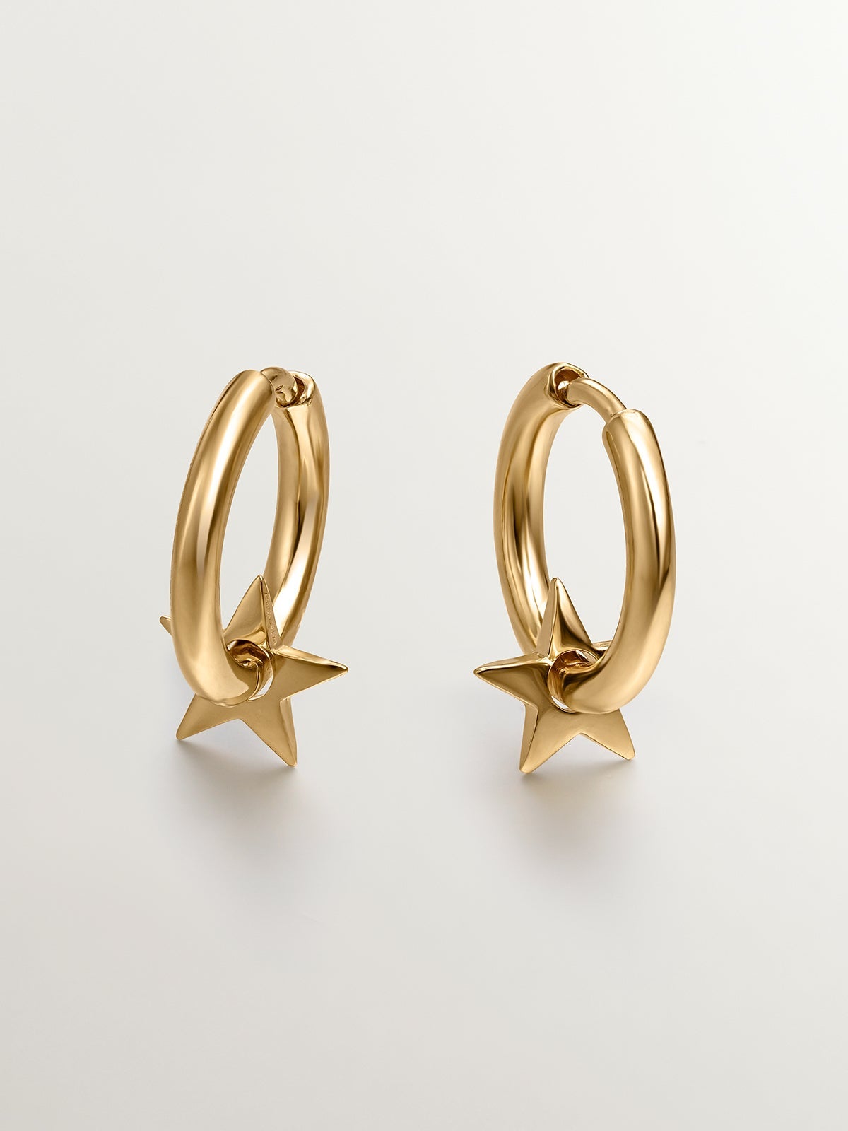 Small hoop earrings made of 925 silver, bathed in 18K gold with a star.