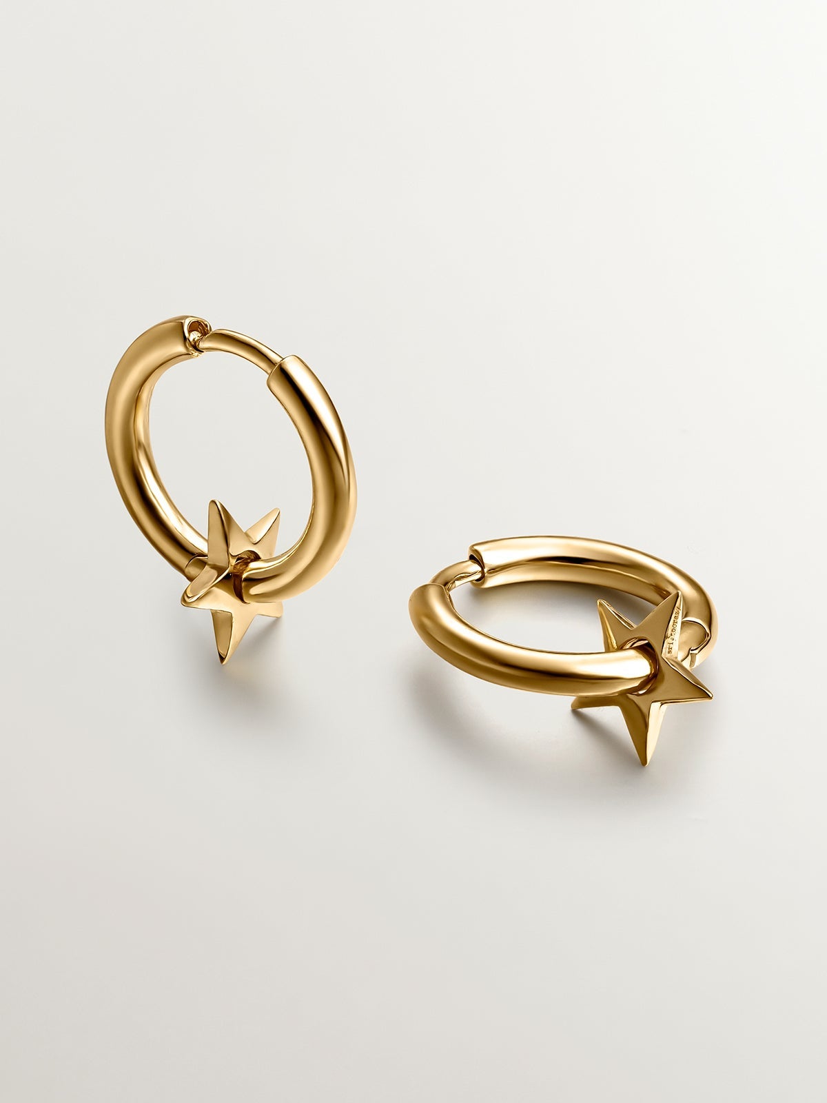 Small hoop earrings made of 925 silver, bathed in 18K gold with a star.