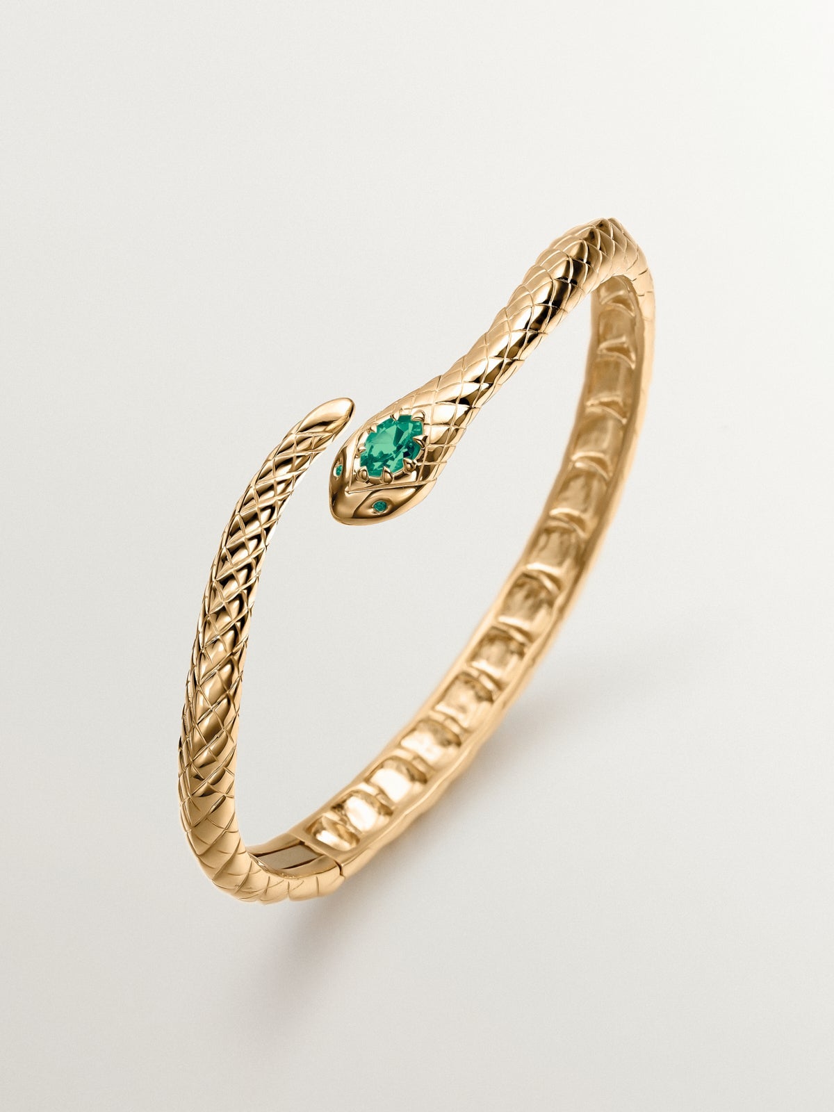 Rigid bracelet made of 925 silver plated in 18K yellow gold with green onyx and shaped like a snake