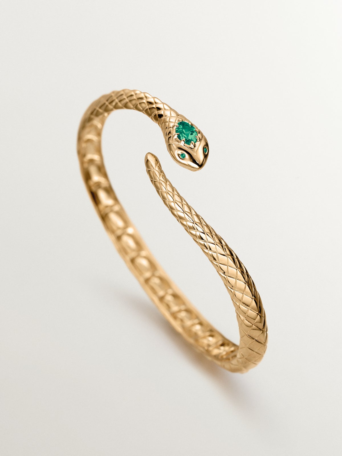 Rigid bracelet made of 925 silver plated in 18K yellow gold with green onyx and shaped like a snake