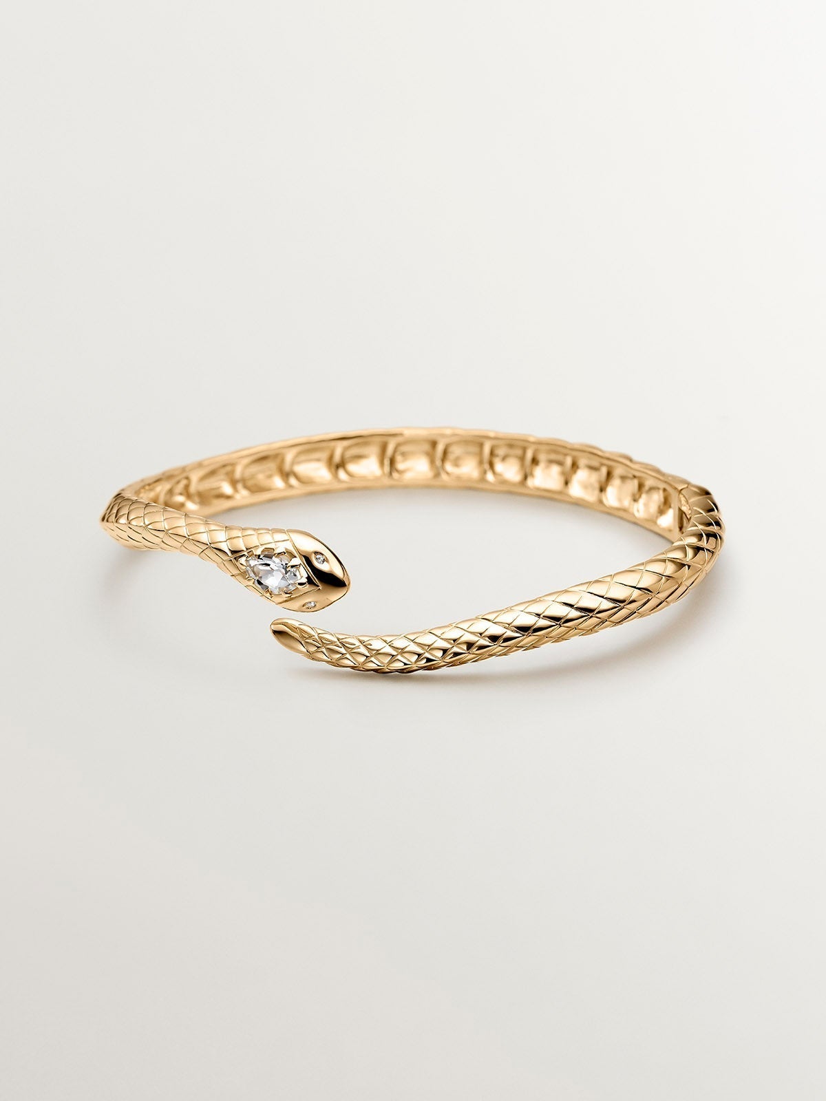 925 Silver bracelet bathed in 18K yellow gold with a snake shape, topazes and white sapphires.