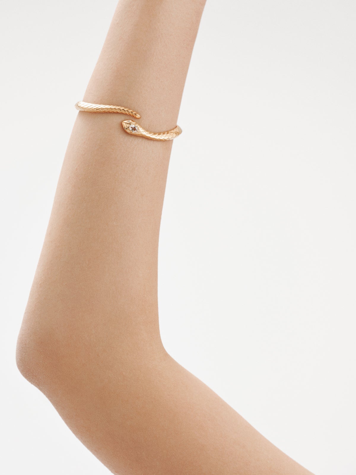 925 Silver bracelet bathed in 18K yellow gold with a snake shape, topazes and white sapphires.