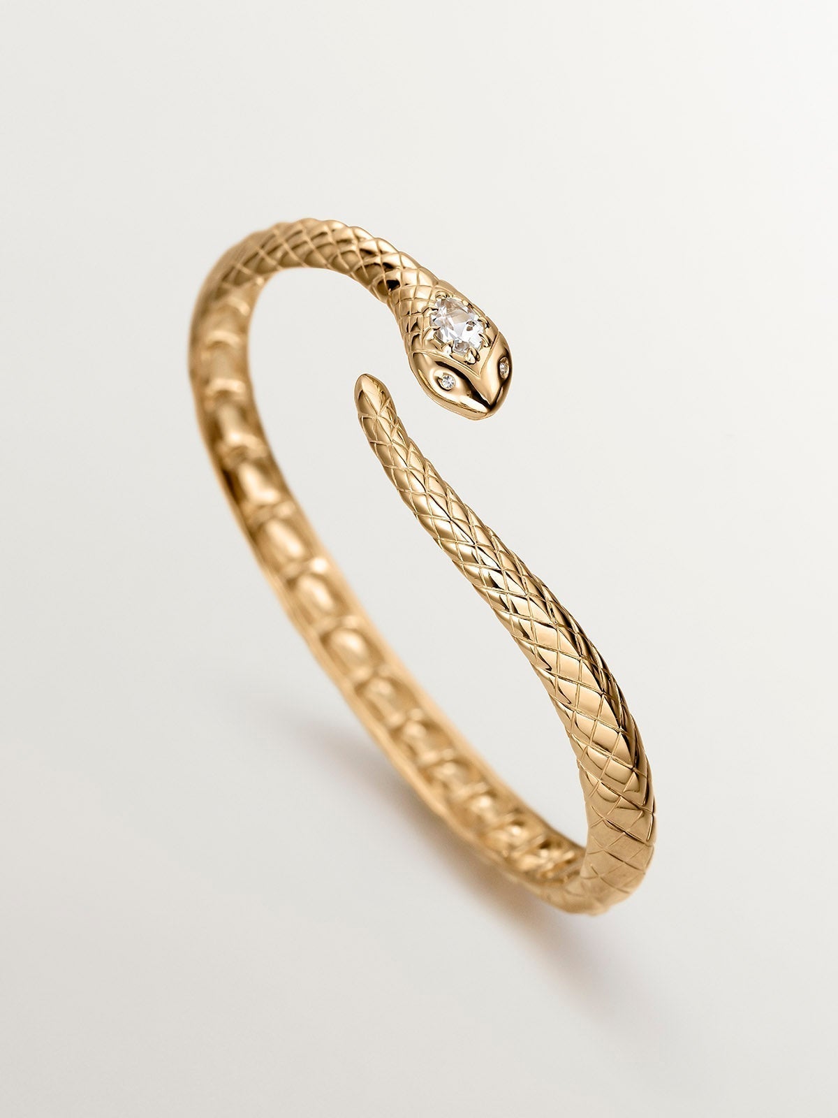925 Silver bracelet bathed in 18K yellow gold with a snake shape, topazes and white sapphires.