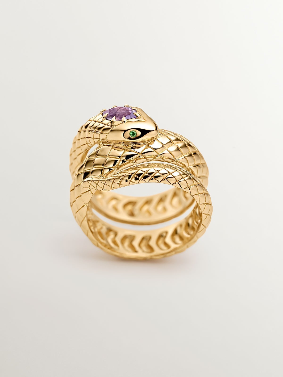 Wide 925 silver ring bathed in 18K yellow gold with a snake shape, purple amethyst and green tsavorites.