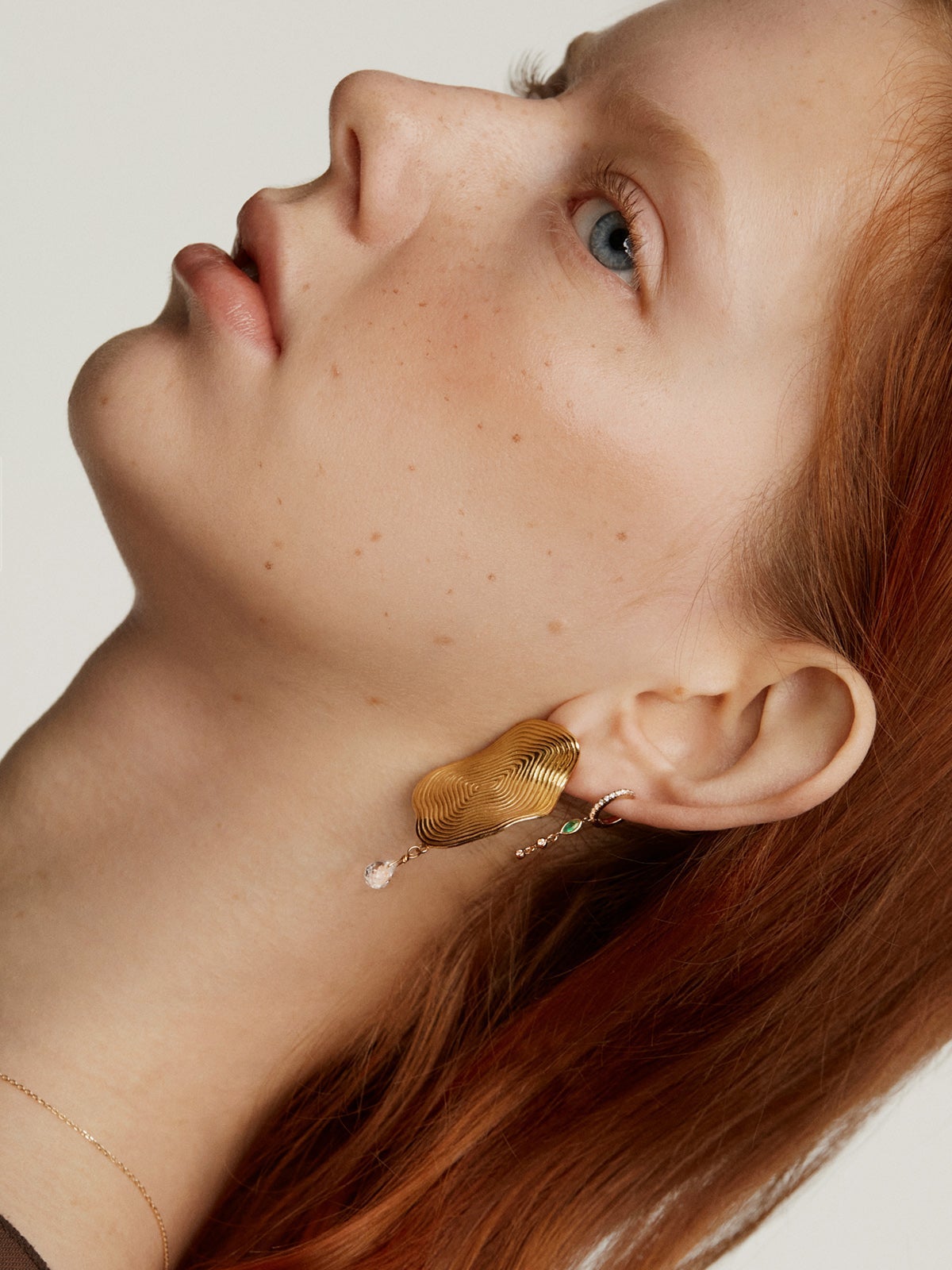Individual small hoop earring made of 9K yellow gold with a diamond chain and emerald.