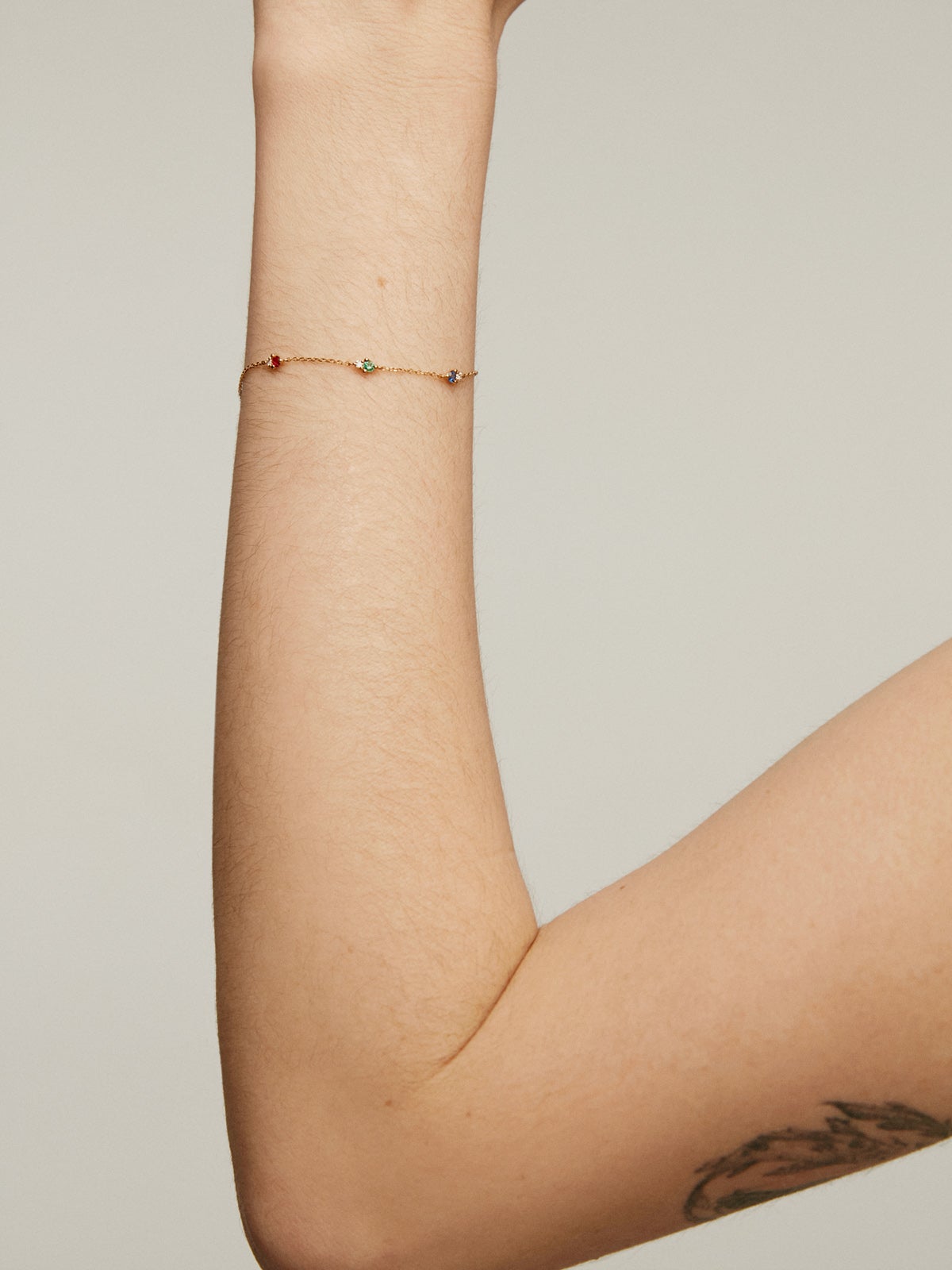9K yellow gold bracelet with sapphire, emerald, ruby, and diamonds.