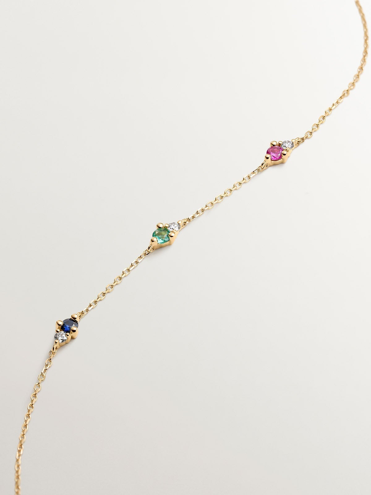 9K yellow gold bracelet with sapphire, emerald, ruby, and diamonds.